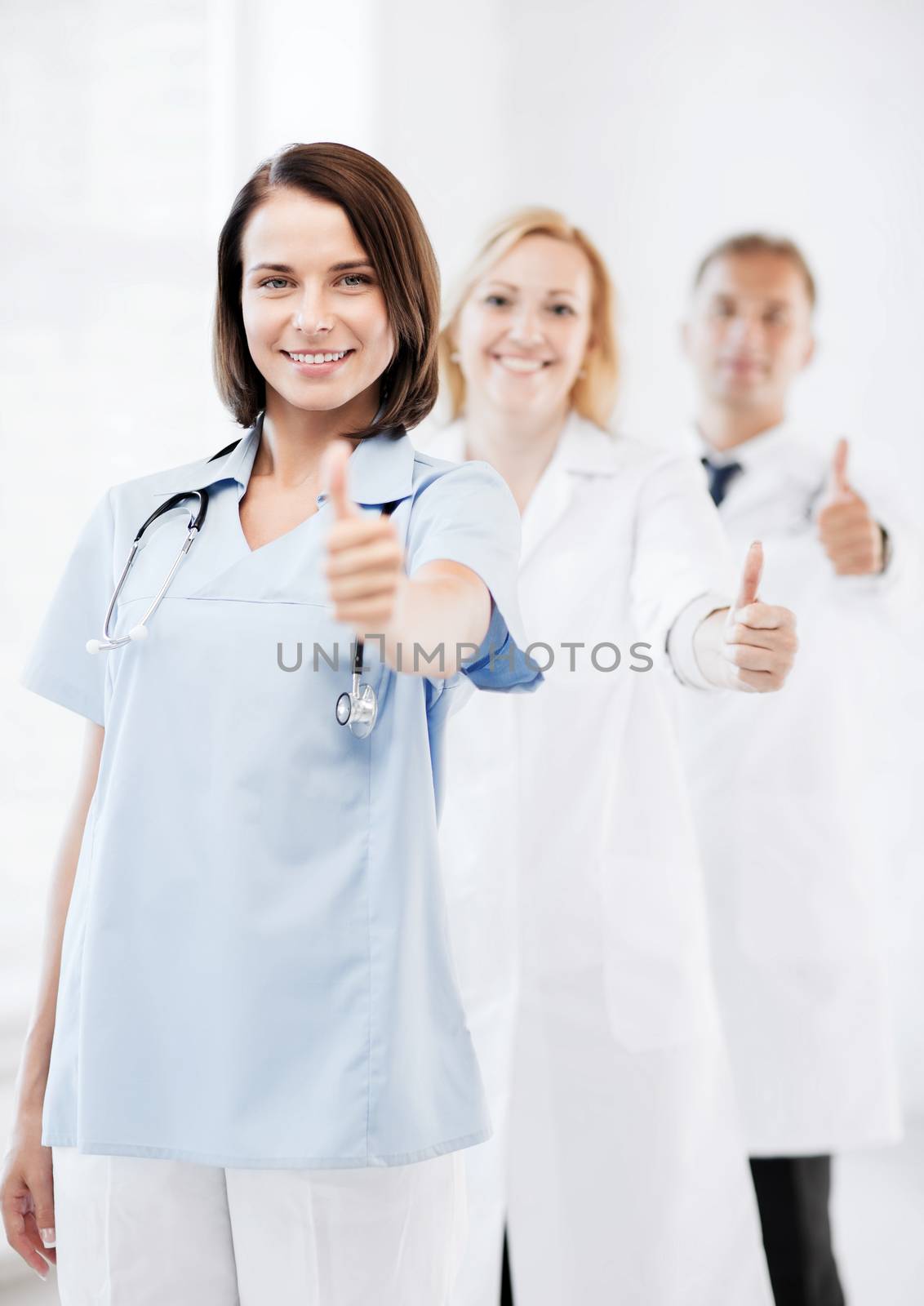 team of doctors showing thumbs up by dolgachov