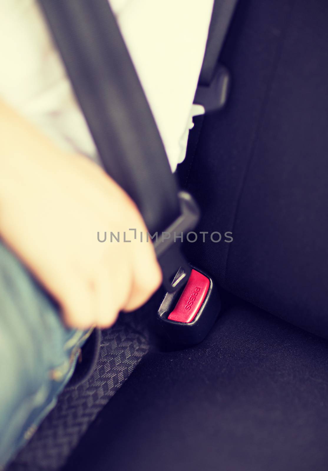 man fastening seat belt in car by dolgachov