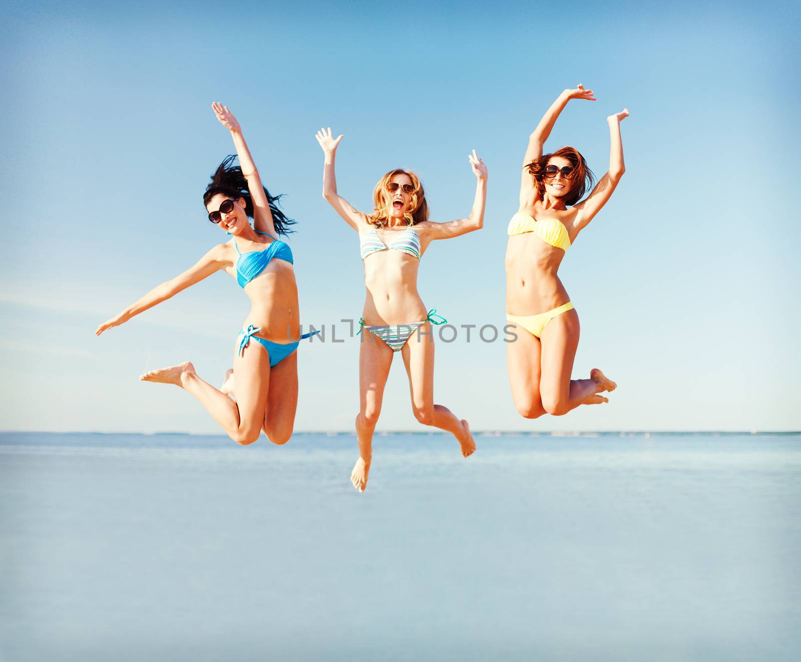 girls jumping on the beach by dolgachov