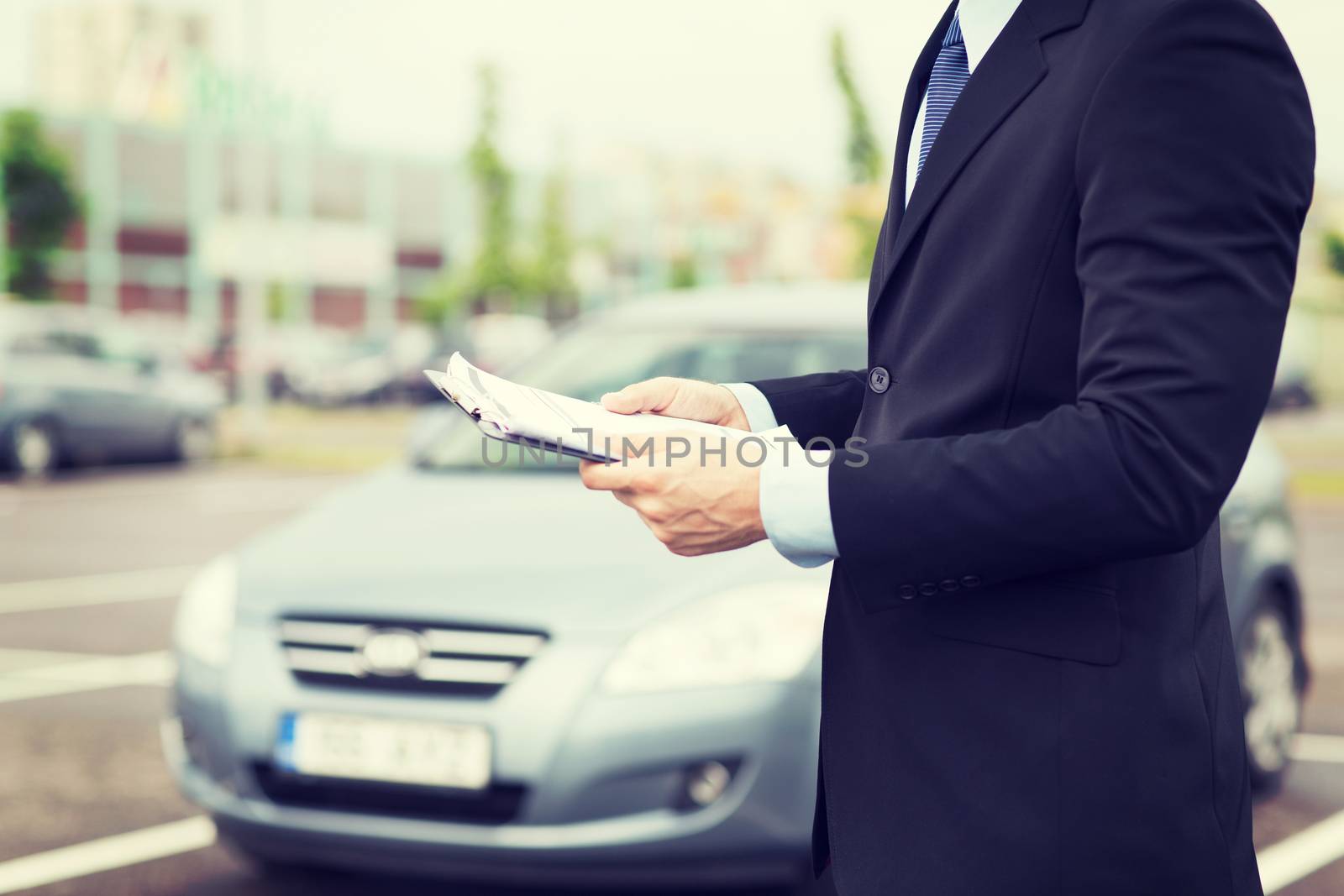man with car documents outside by dolgachov