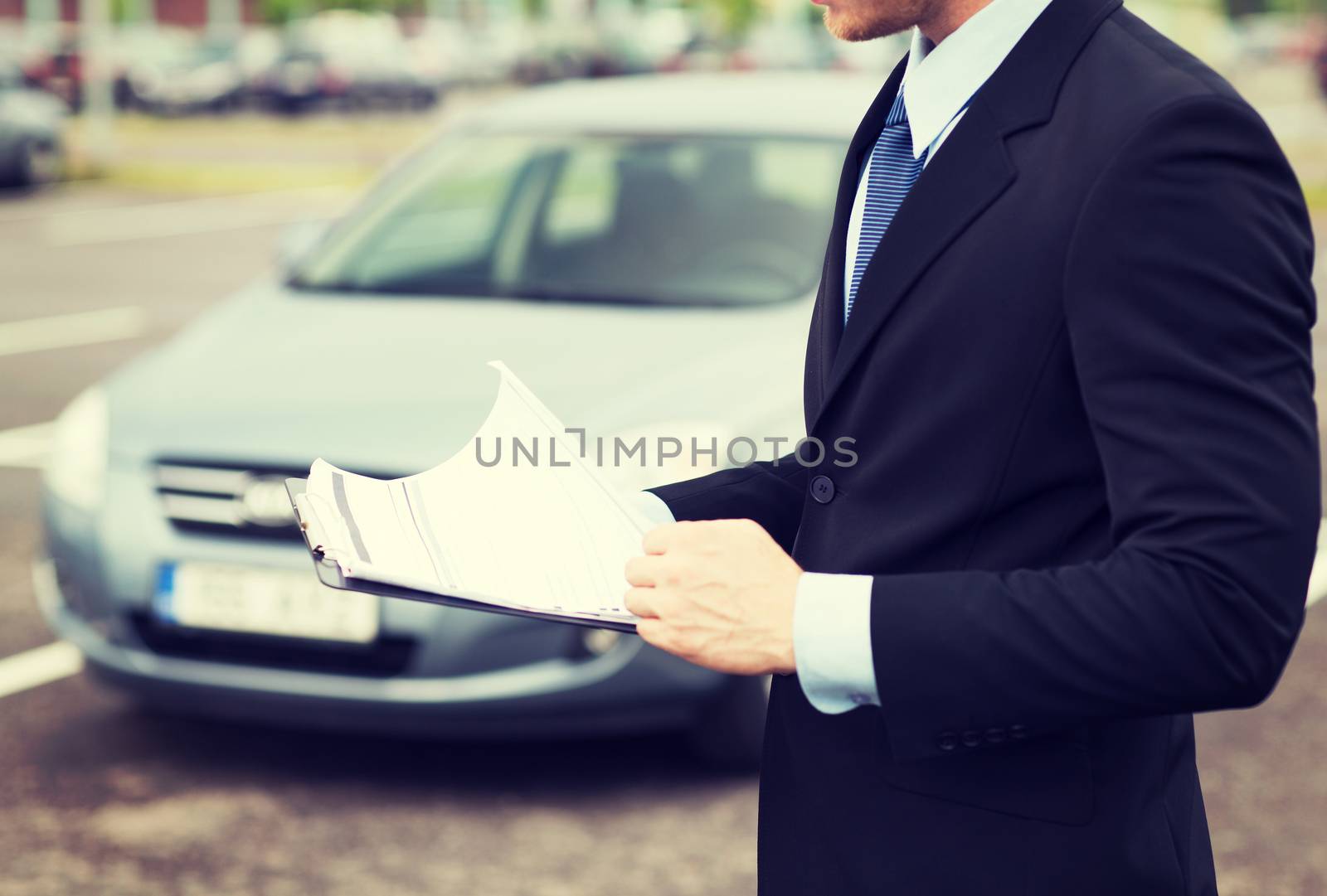 transportation and ownership concept - man with car documents outside