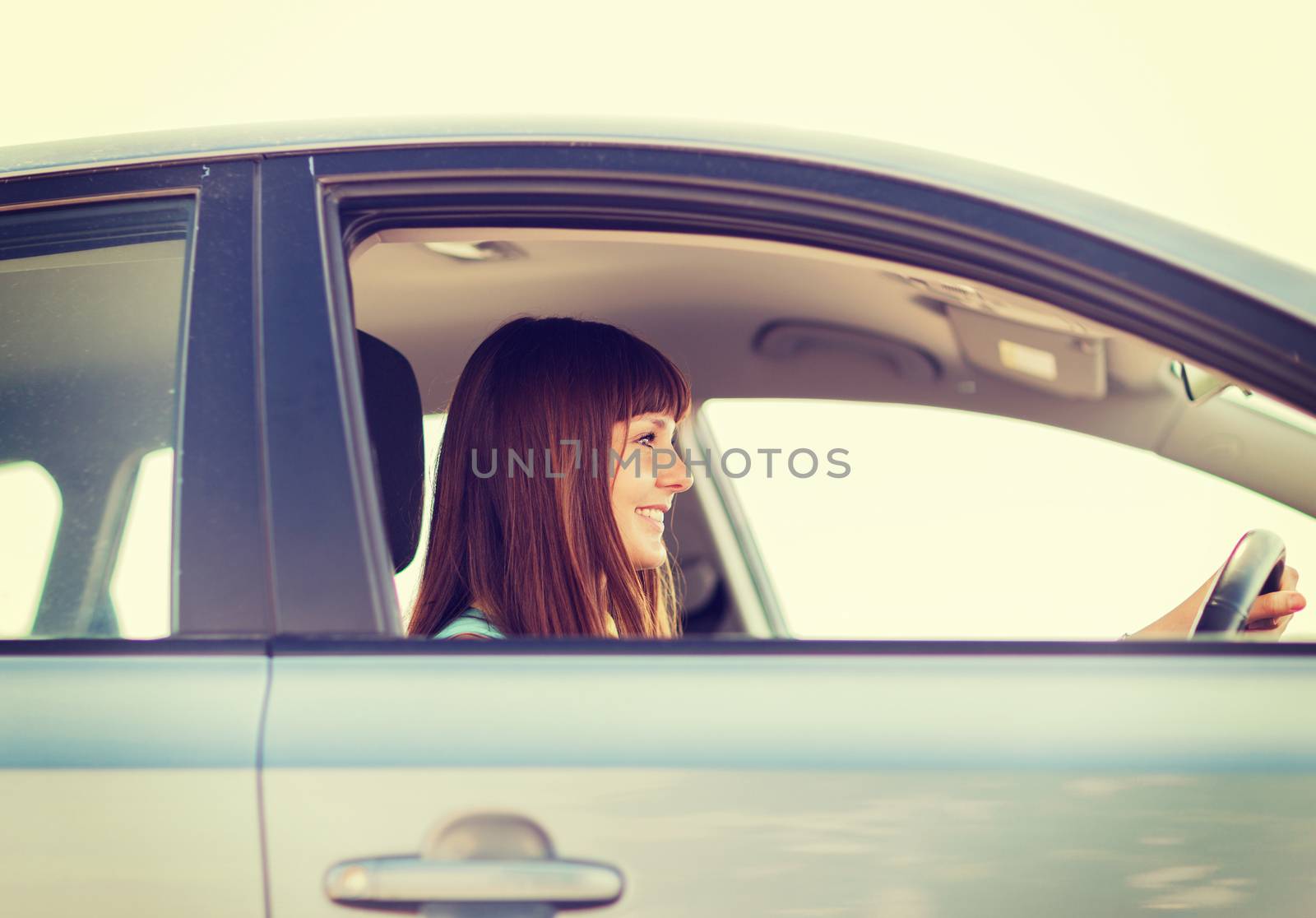 happy woman driving a car by dolgachov