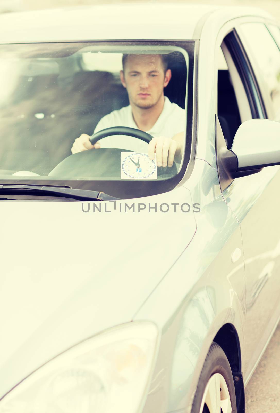 transportation and vehicle concept - man placing parking clock on car dashboard under windscreen