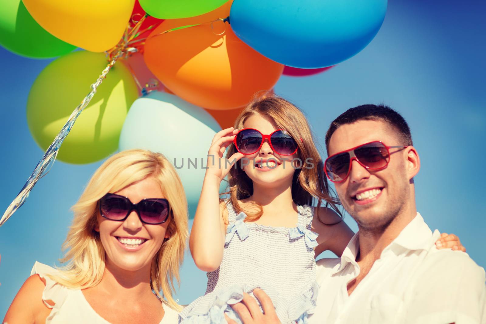 happy family with colorful balloons outdoors by dolgachov