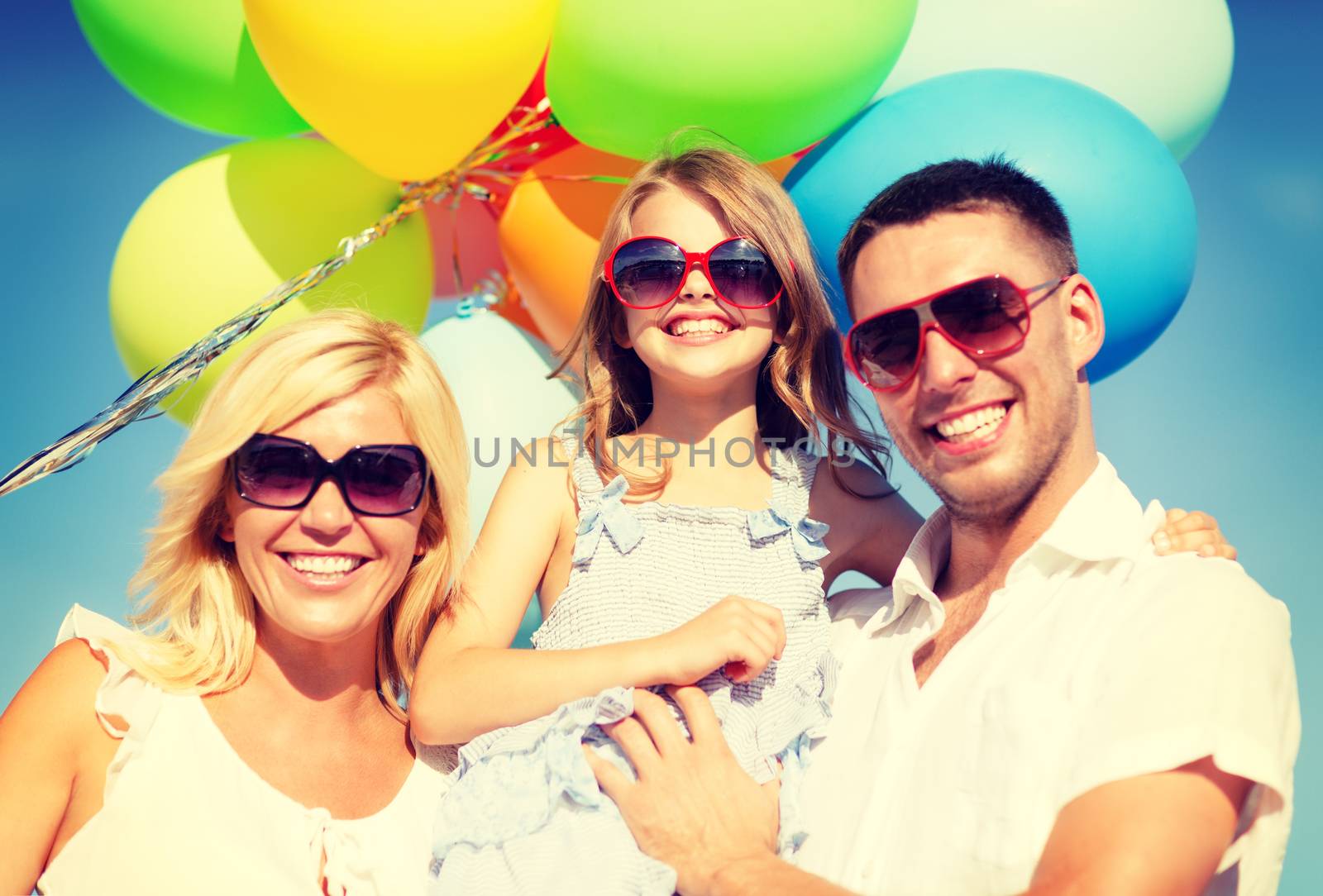 summer holidays, celebration, children and people concept - happy family with colorful balloons outdoors