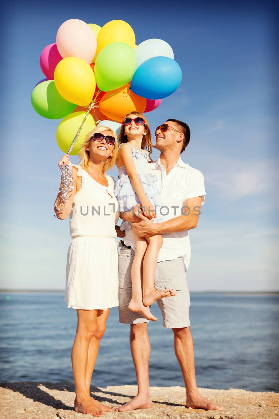 summer holidays, celebration, children and people concept - happy family with colorful balloons at seaside