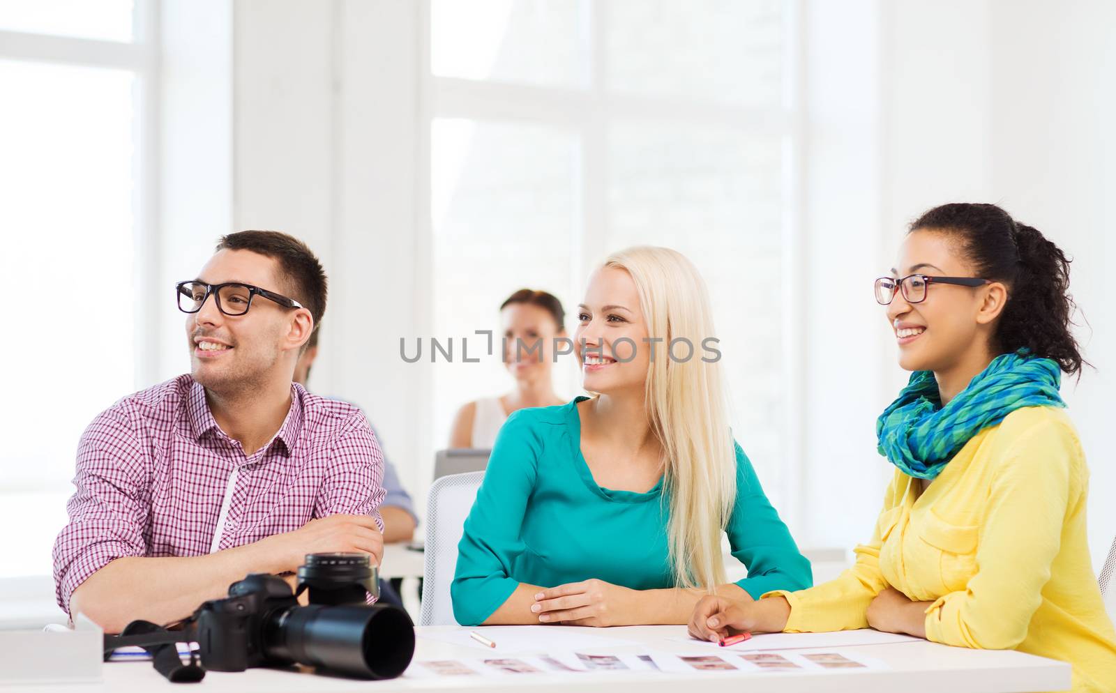 business, education, photography, office and startup concept - smiling creative team with photocamera listening to lecture in office