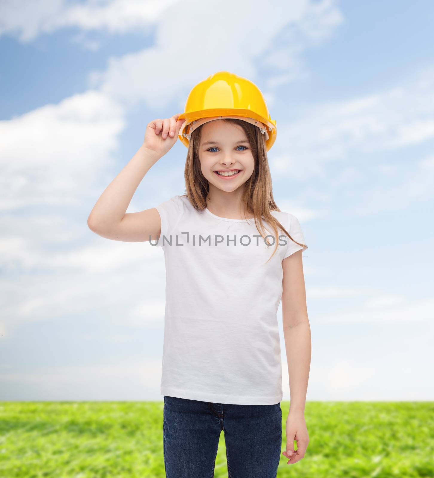 construction and people concept - smiling little girl in protective helmet
