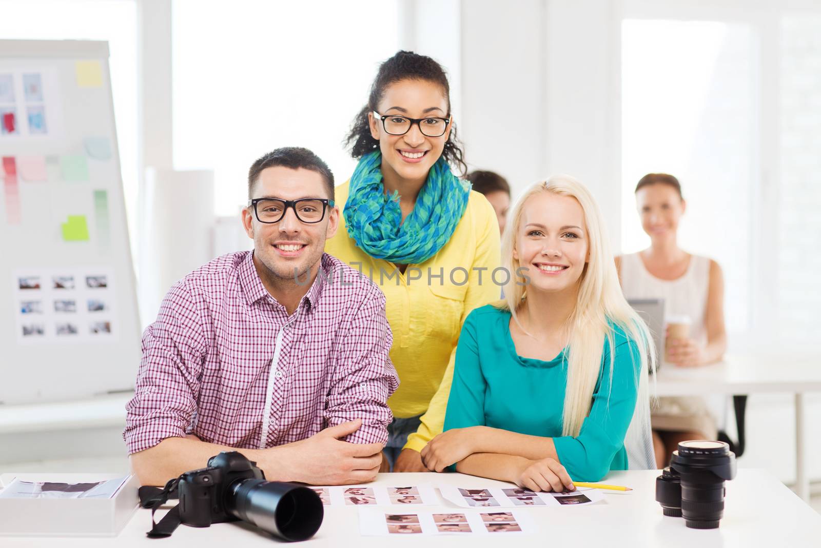 smiling team with printed photos working in office by dolgachov