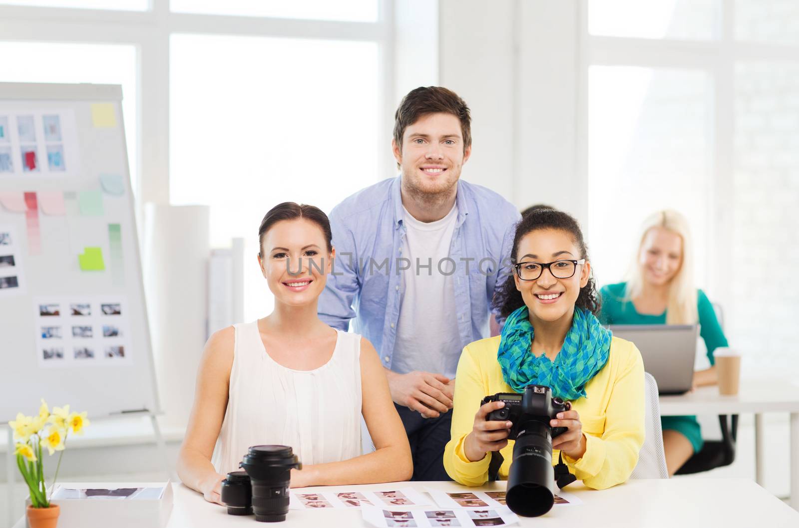 business, education, photography, office and startup concept - smiling creative team with photocamera working in office