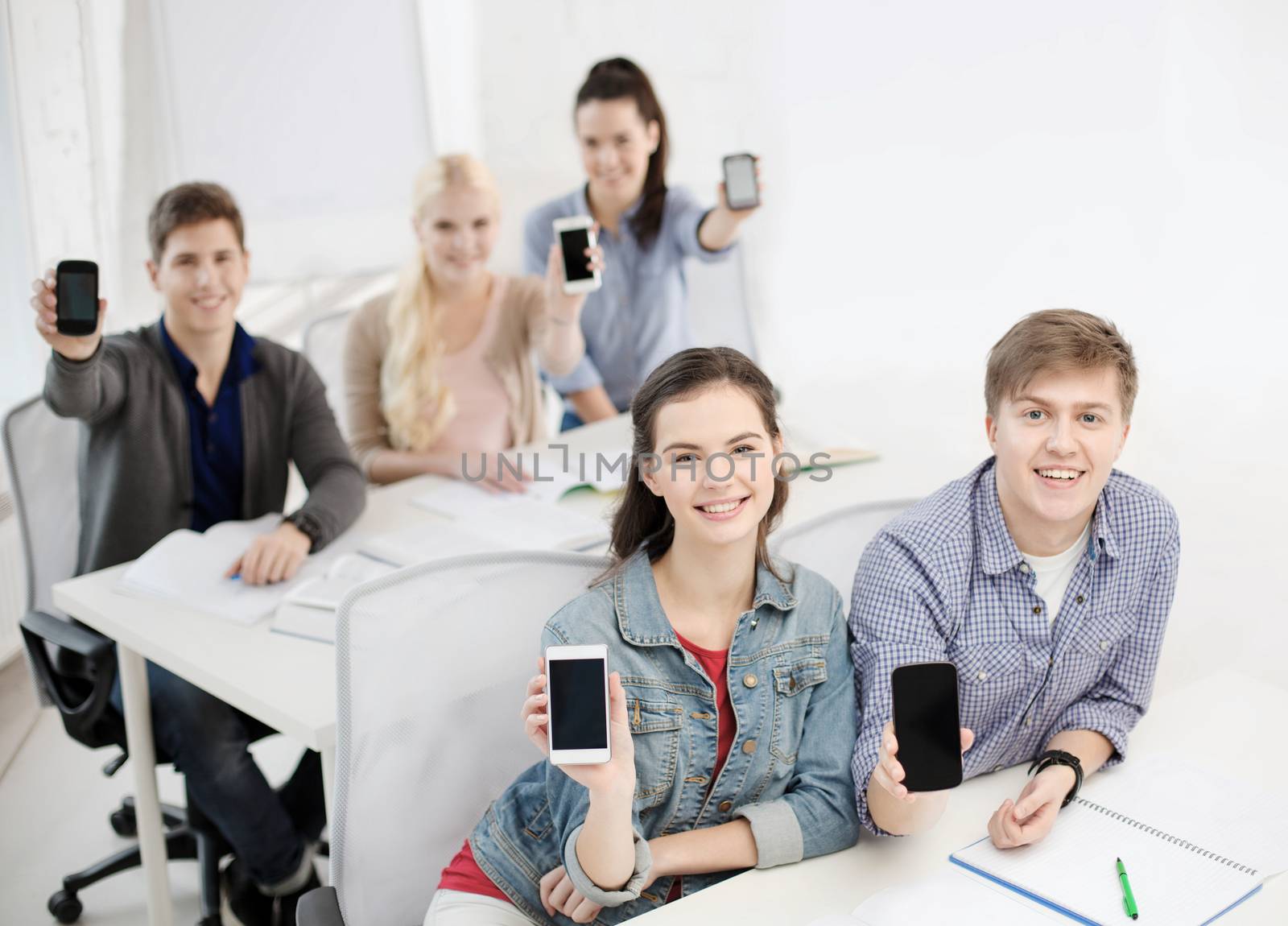 students showing black blank smartphone screens by dolgachov