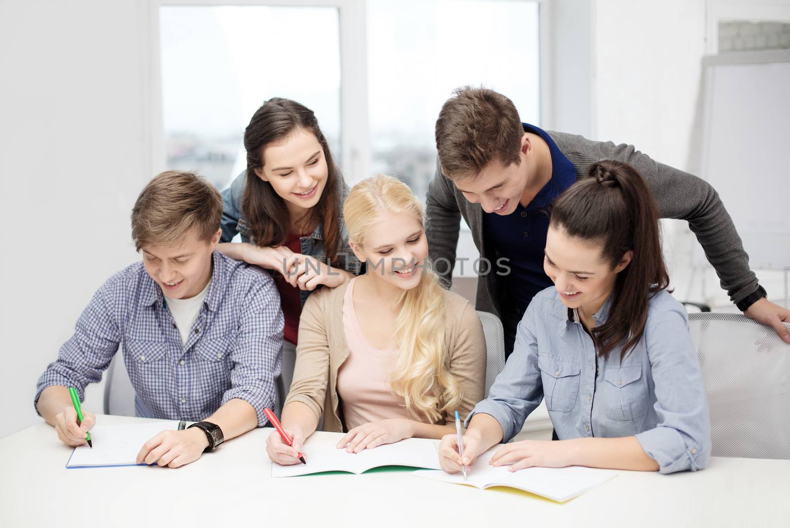 school and education concept - group of smiling students with notebooks at school