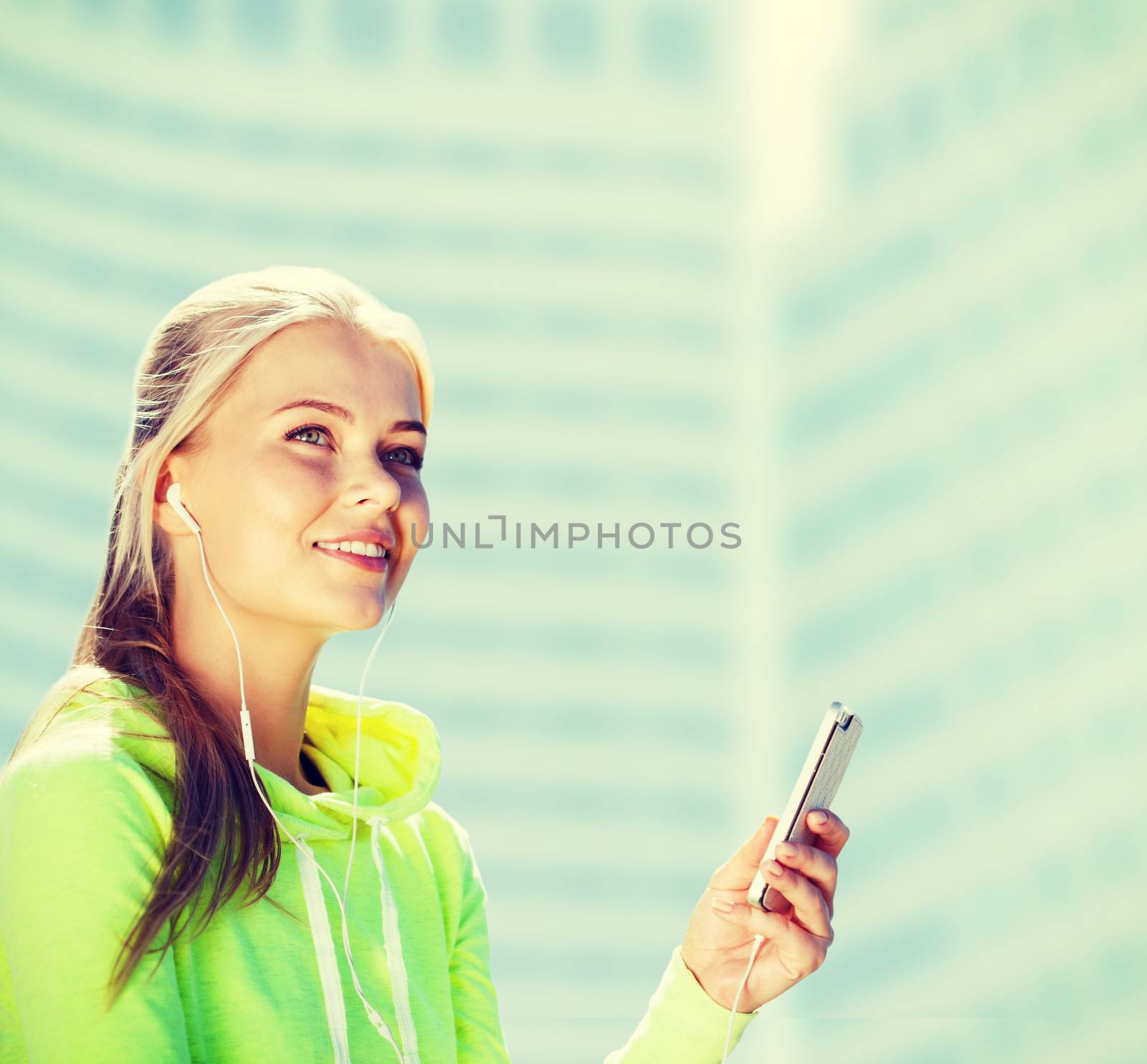 sport and lifestyle concept - woman doing sports and listening to music outdoors