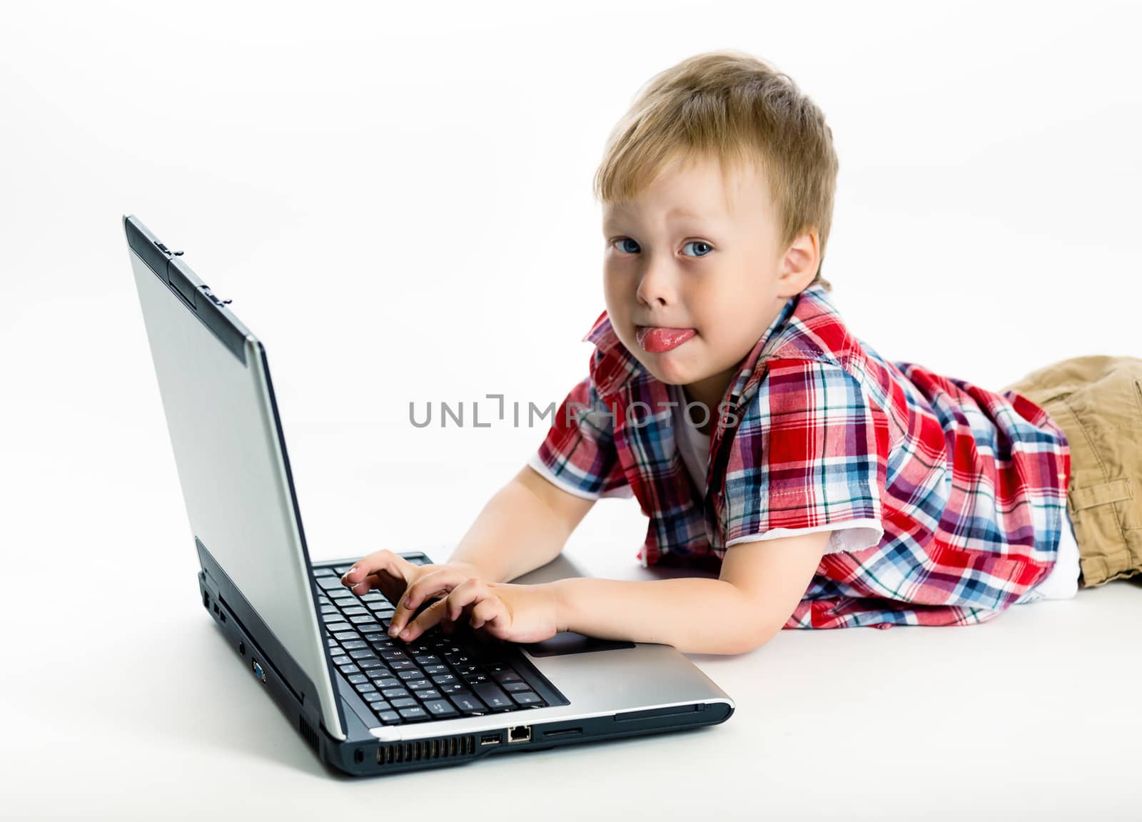 Little boy lying on the floor with a laptop