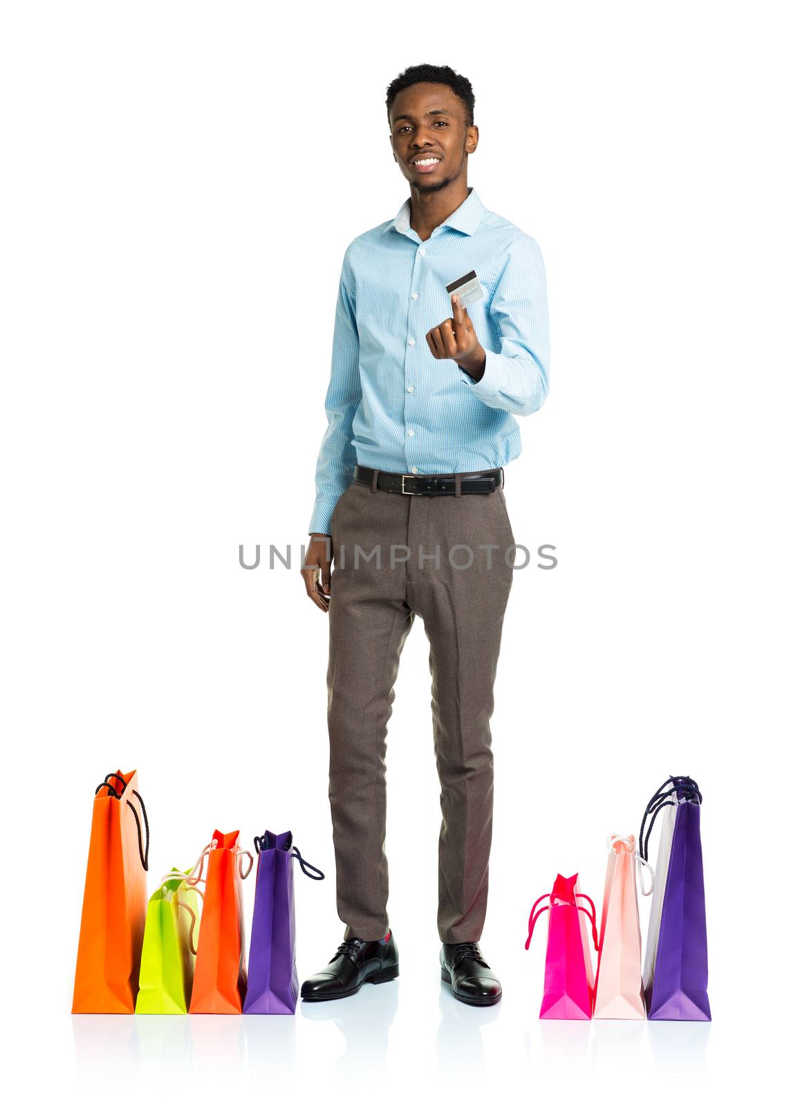 Happy african american man with shopping bags and holding credit card on white background. Shopping and holidays concept
