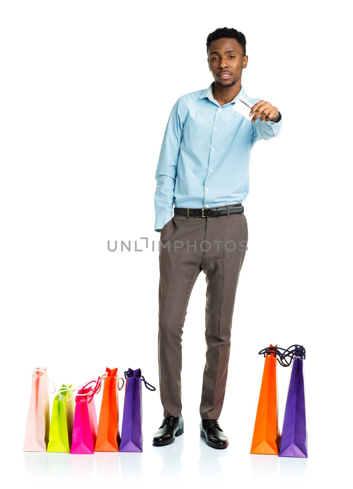 African american man with shopping bags and holding credit card on white background. Shopping and holidays concept