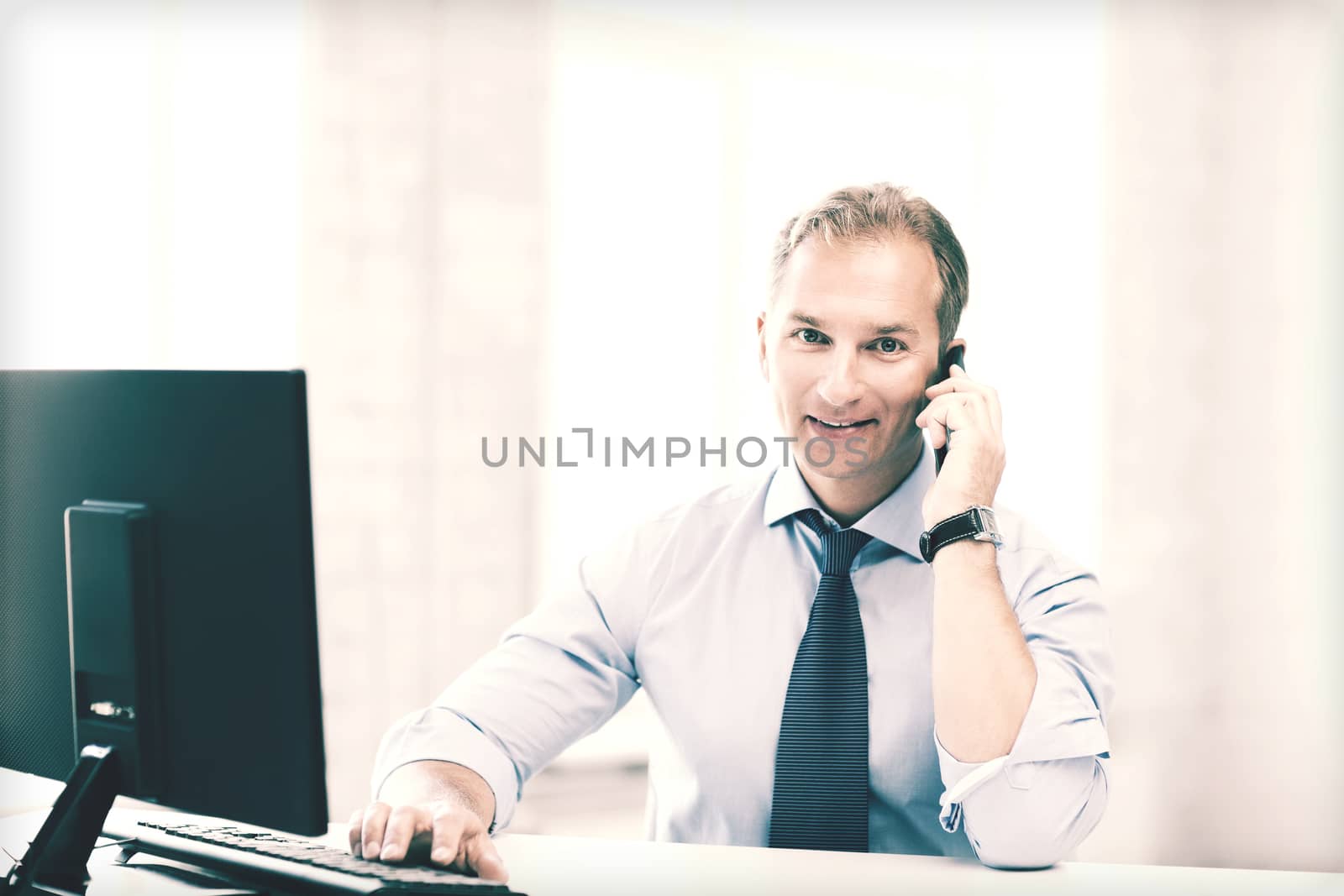 smiling businessman with smartphone in office by dolgachov