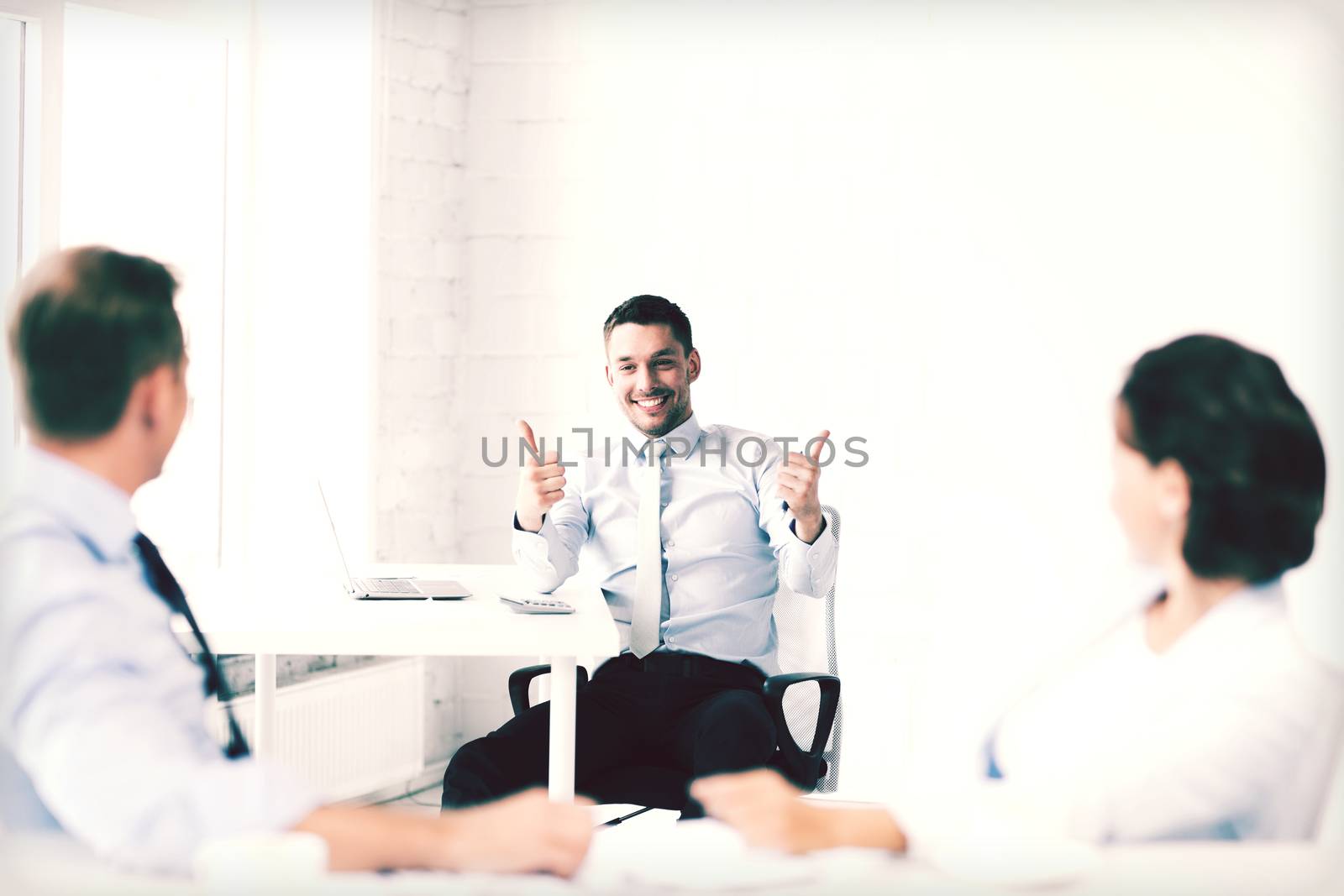 businessman showing thumbs up in office by dolgachov