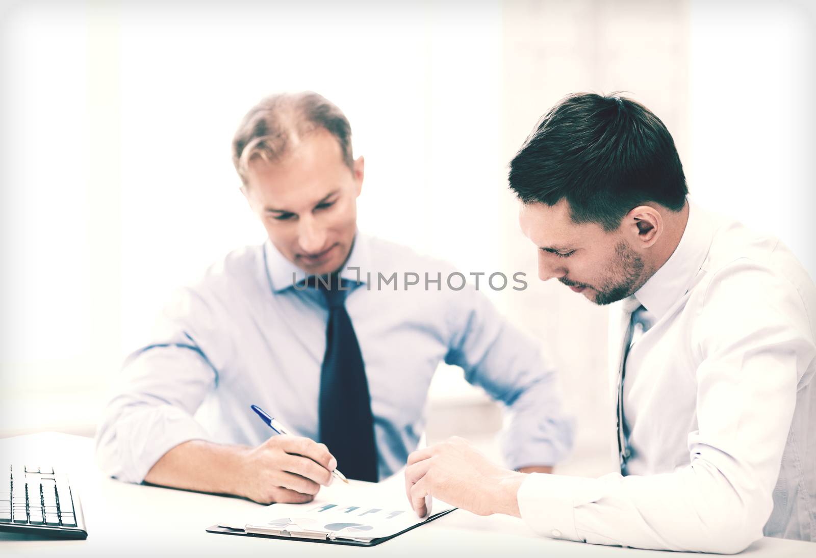 businesss concept - two businessmen discussing graphs on meeting