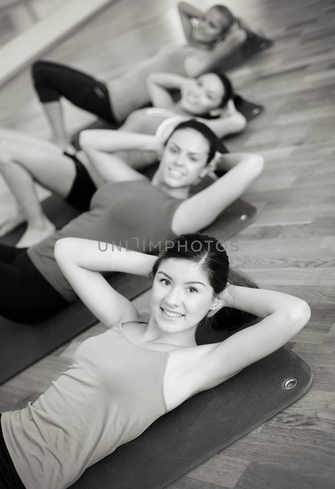 fitness, sport, training, gym and lifestyle concept - group of smiling women exercising on mats in the gym