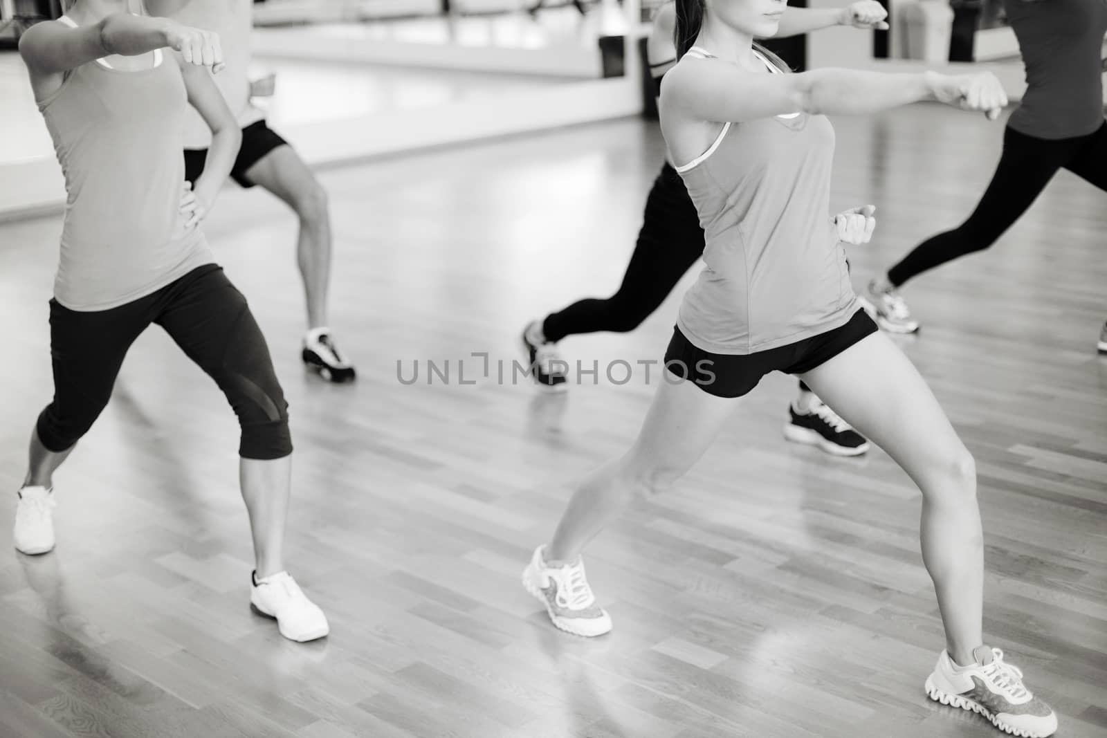 fitness, sport, training, gym and lifestyle concept - group of smiling people with trainer exercising in the gym