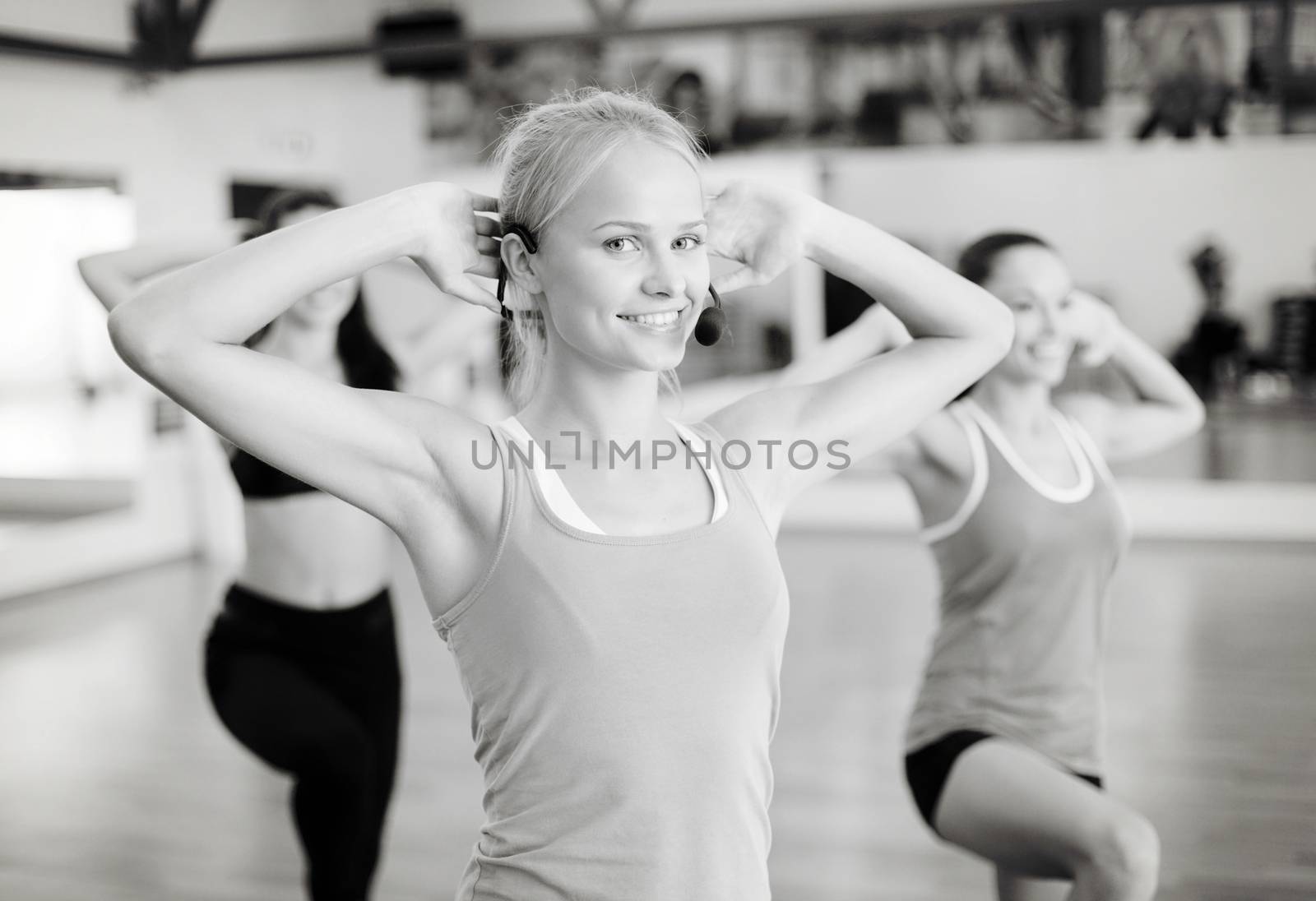 group of smiling people exercising in the gym by dolgachov