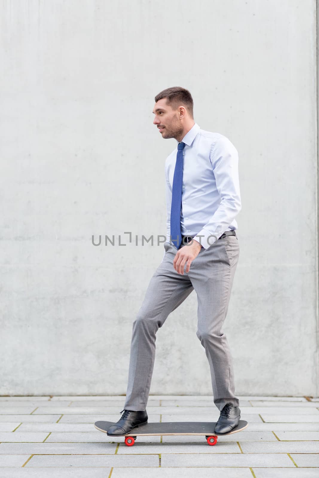 business, hot drinks and people and concept - young smiling businessman riding on skateboard outdoors