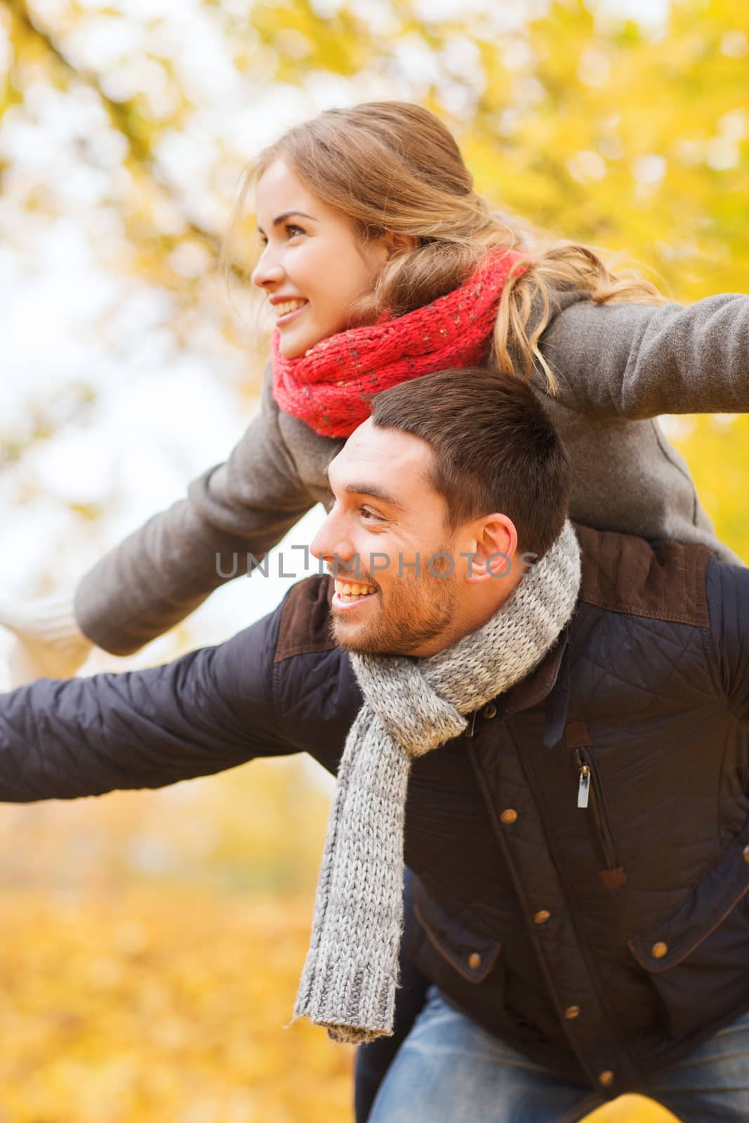 love, relationship, family and people concept - smiling couple having fun in autumn park