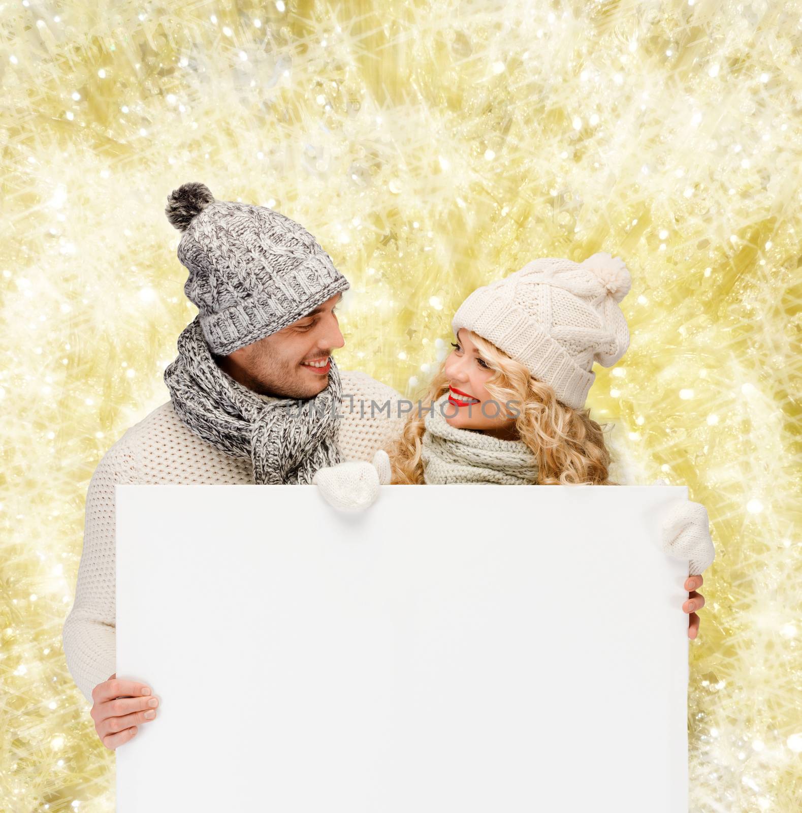smiling couple in winter clothes with white board by dolgachov
