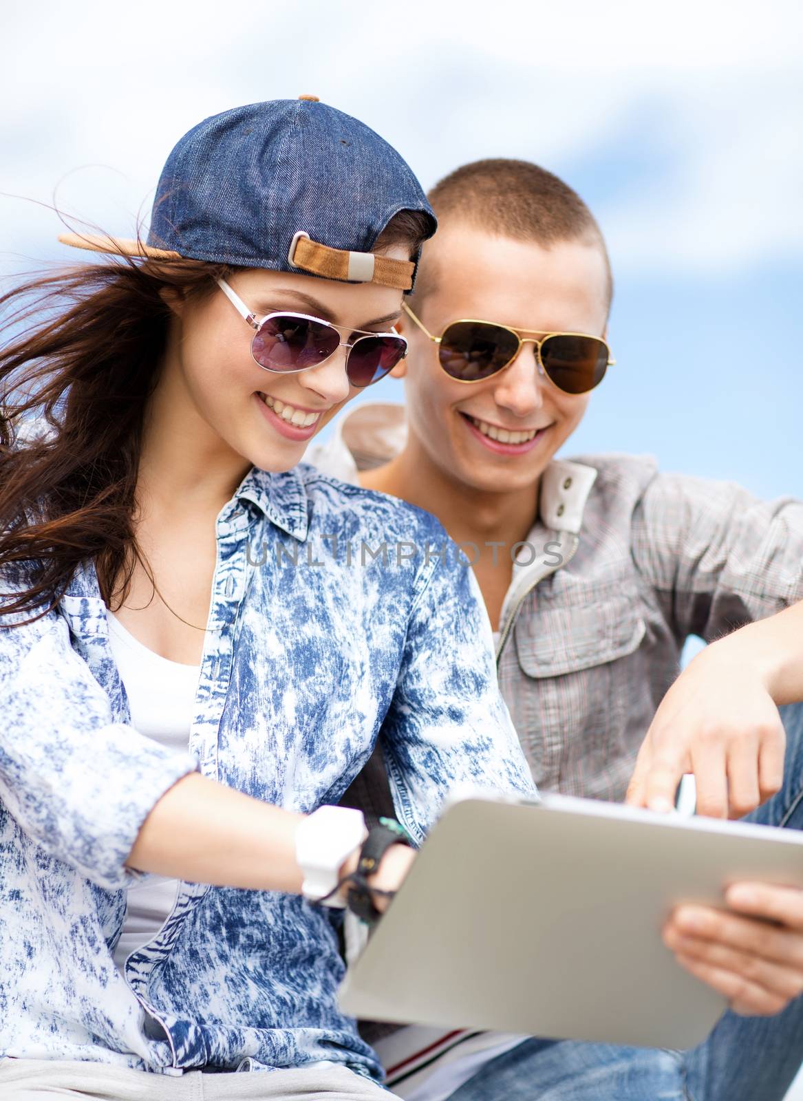 summer holidays, teenage and technology concept - teenagers looking at tablet pc