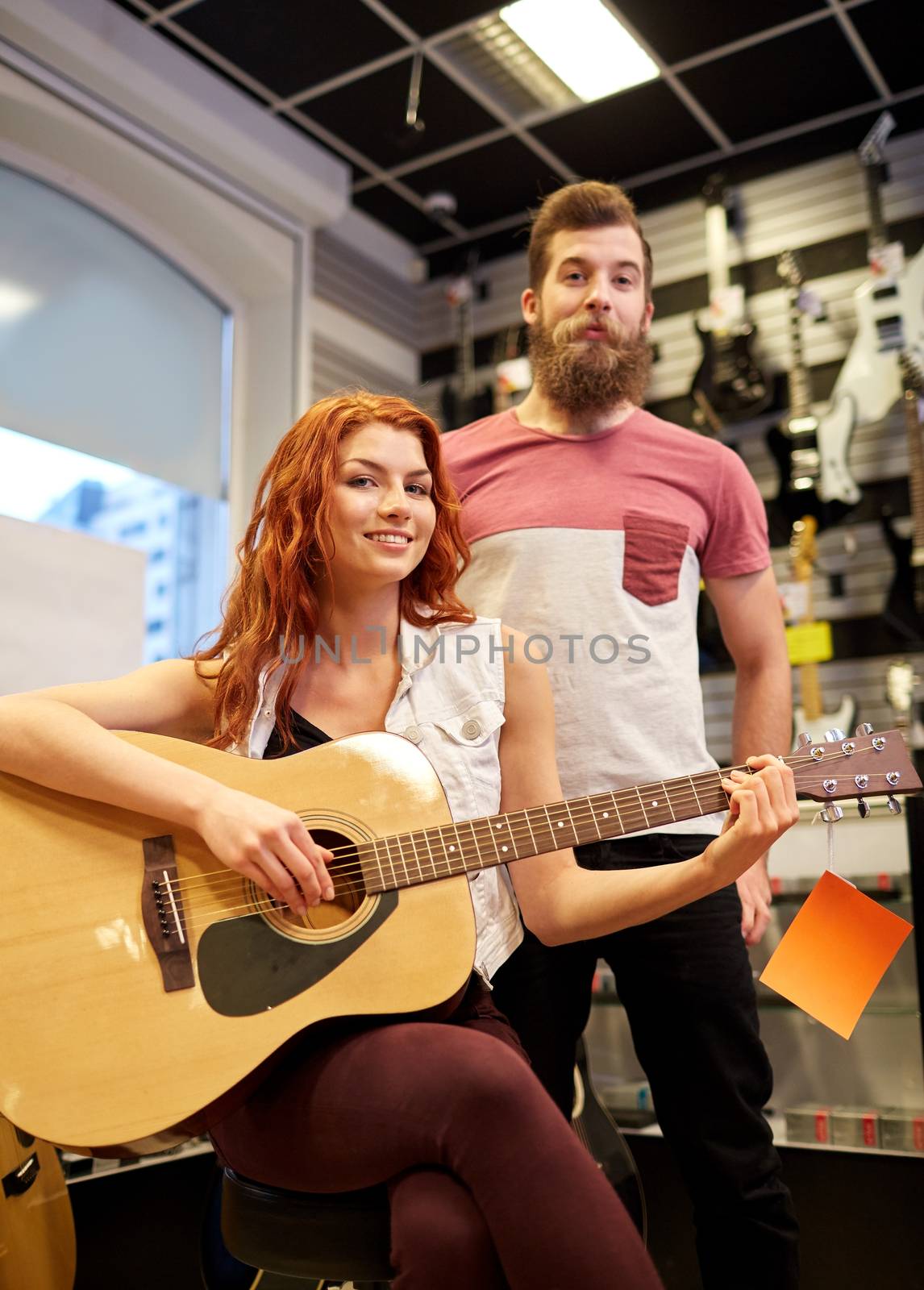 couple of musicians with guitar at music store by dolgachov