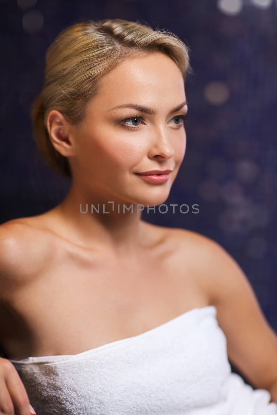 people, beauty, spa, healthy lifestyle and relaxation concept - beautiful young woman sitting in bath towel