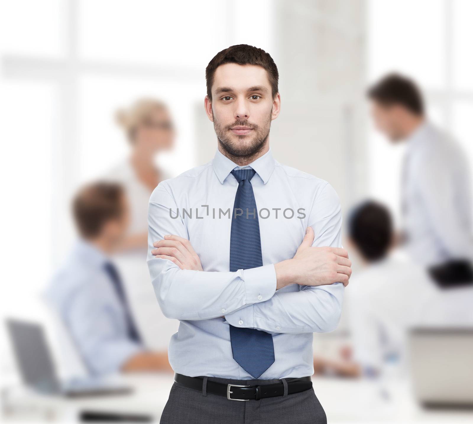 handsome businessman with crossed arms by dolgachov