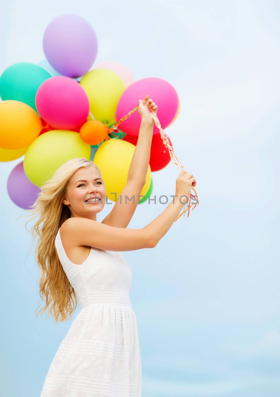 smiling woman with colorful balloons outside by dolgachov