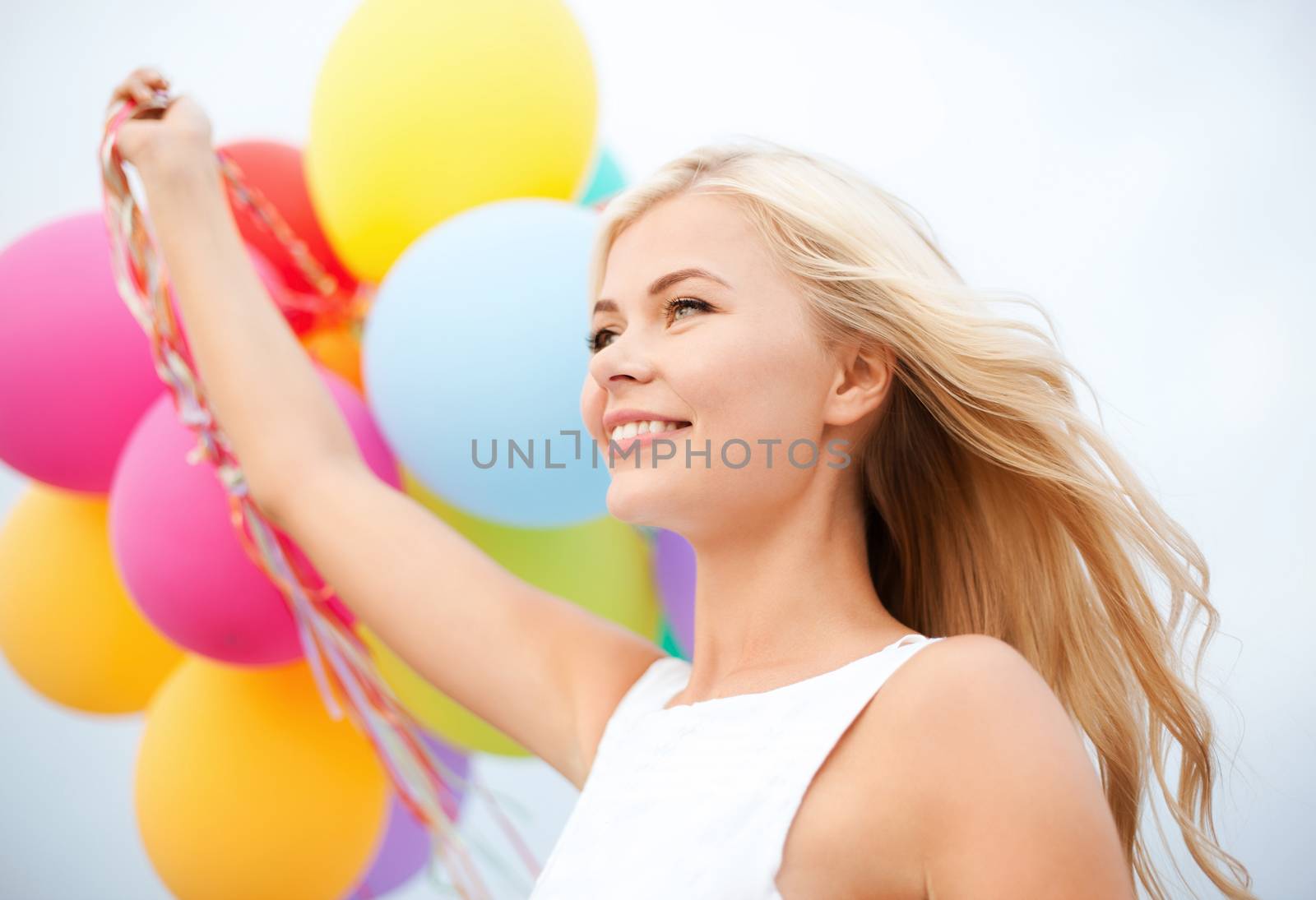 woman with colorful balloons outside by dolgachov