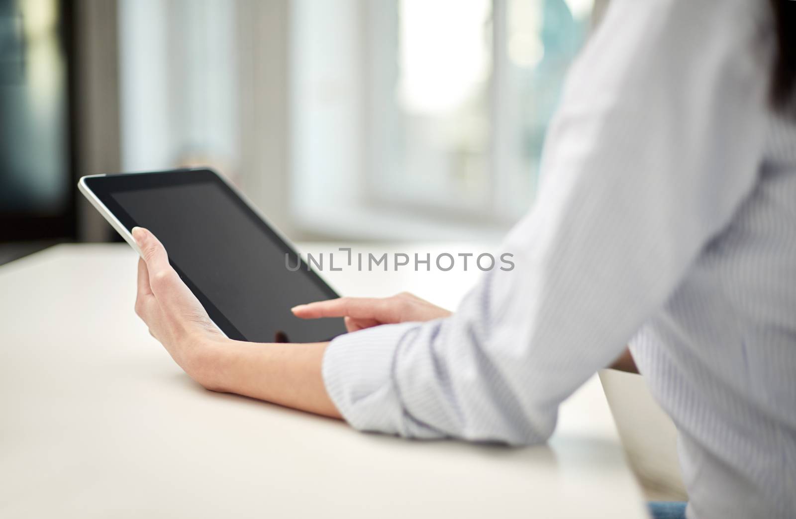 business, technology, communication and people concept - close up of woman with tablet pc computer at office or home