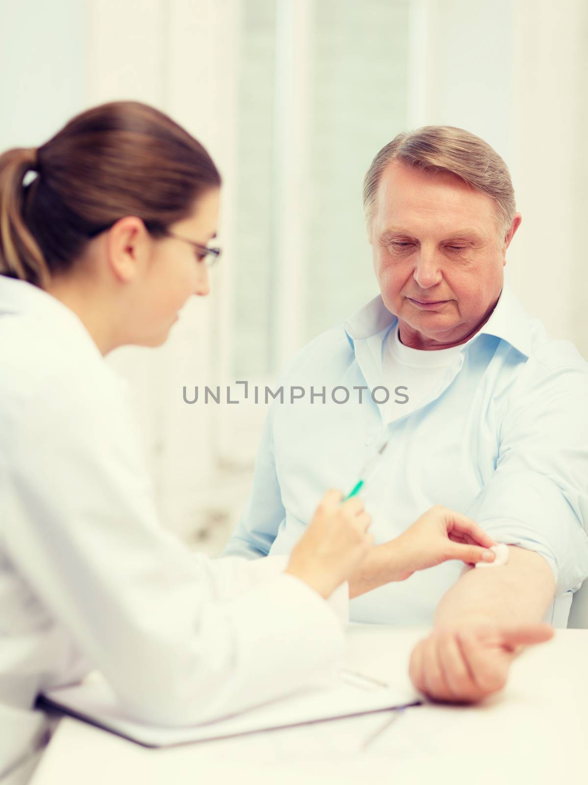 female doctor doing injection to old man by dolgachov