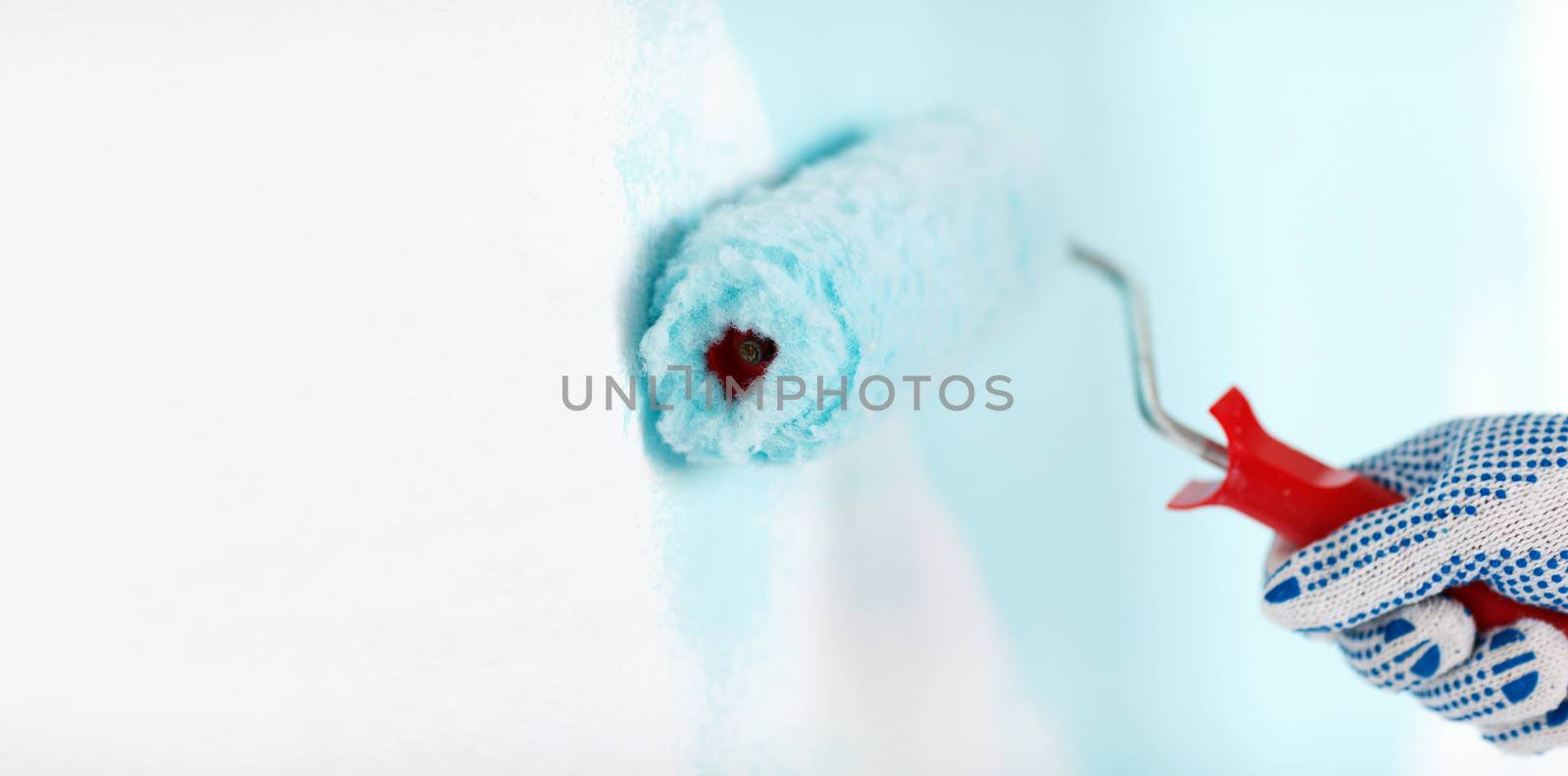 close up of male in gloves painting wall by dolgachov