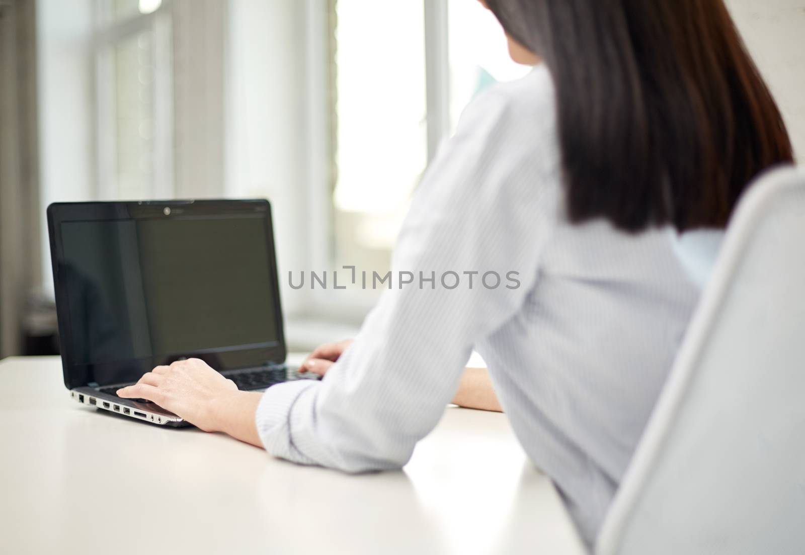 close up of woman typing on laptop at office by dolgachov