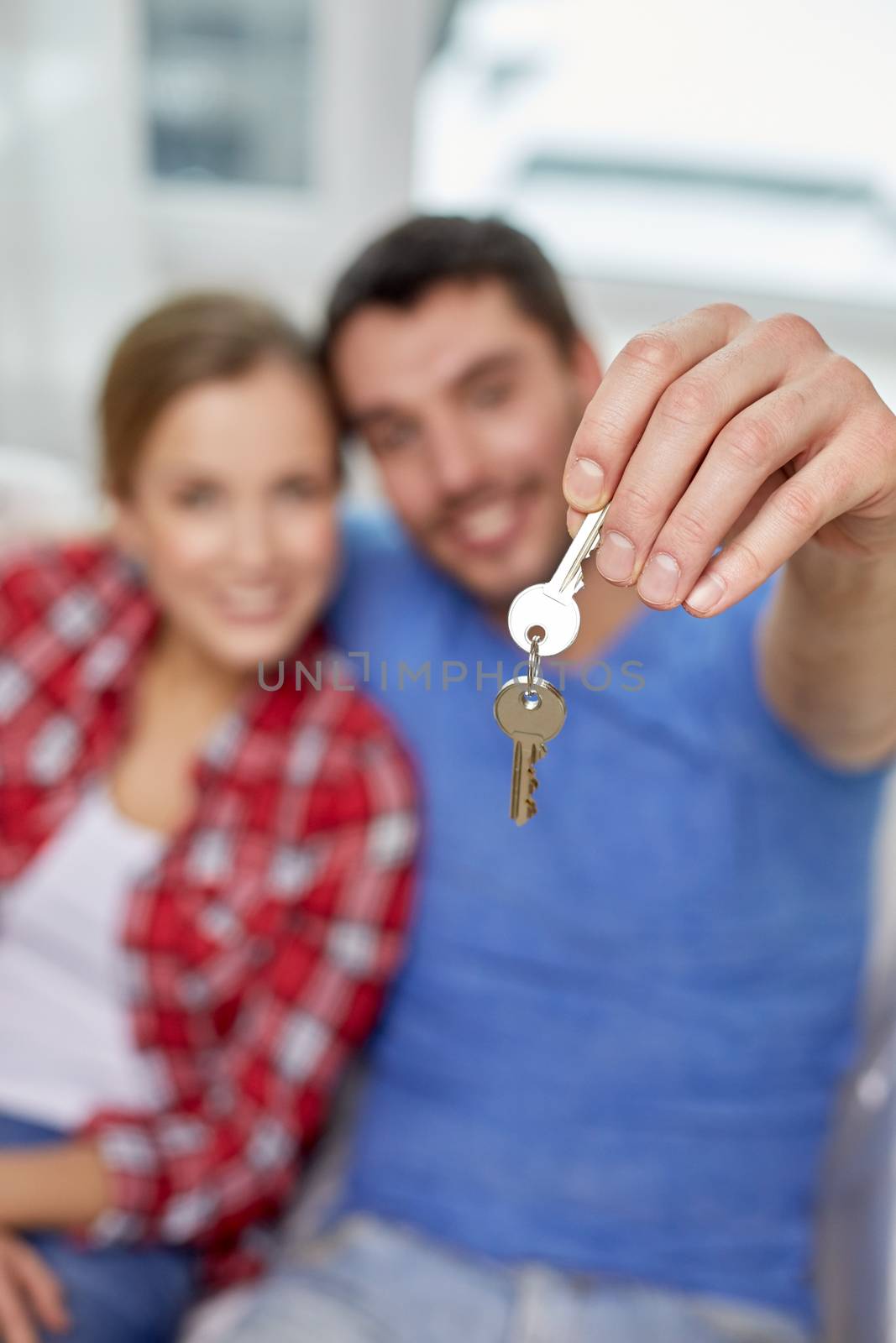people, real estate, home and family concept - close up of happy couple showing key at at home