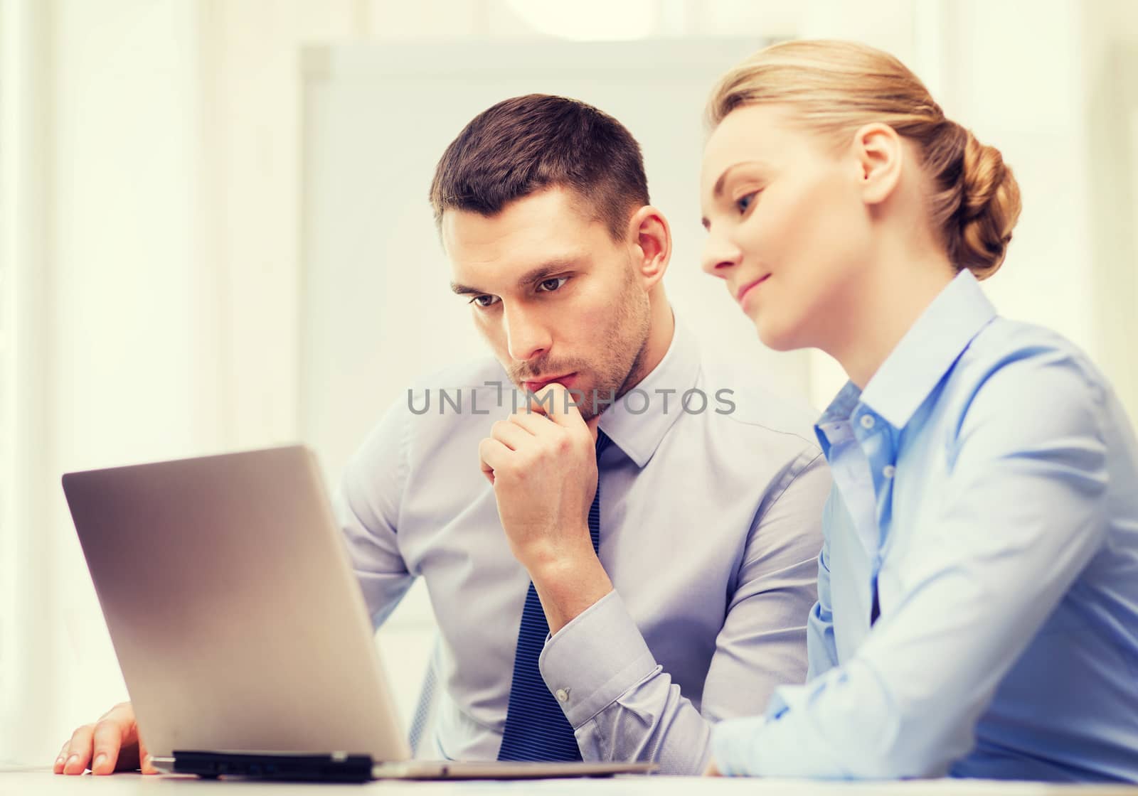 serious business couple with laptop computer by dolgachov