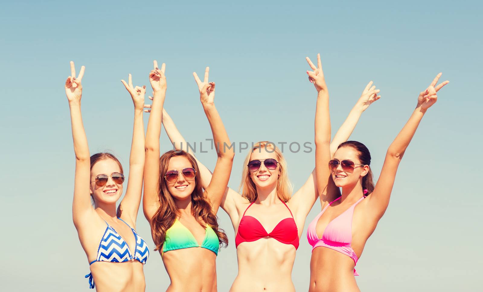 group of smiling young women on beach by dolgachov