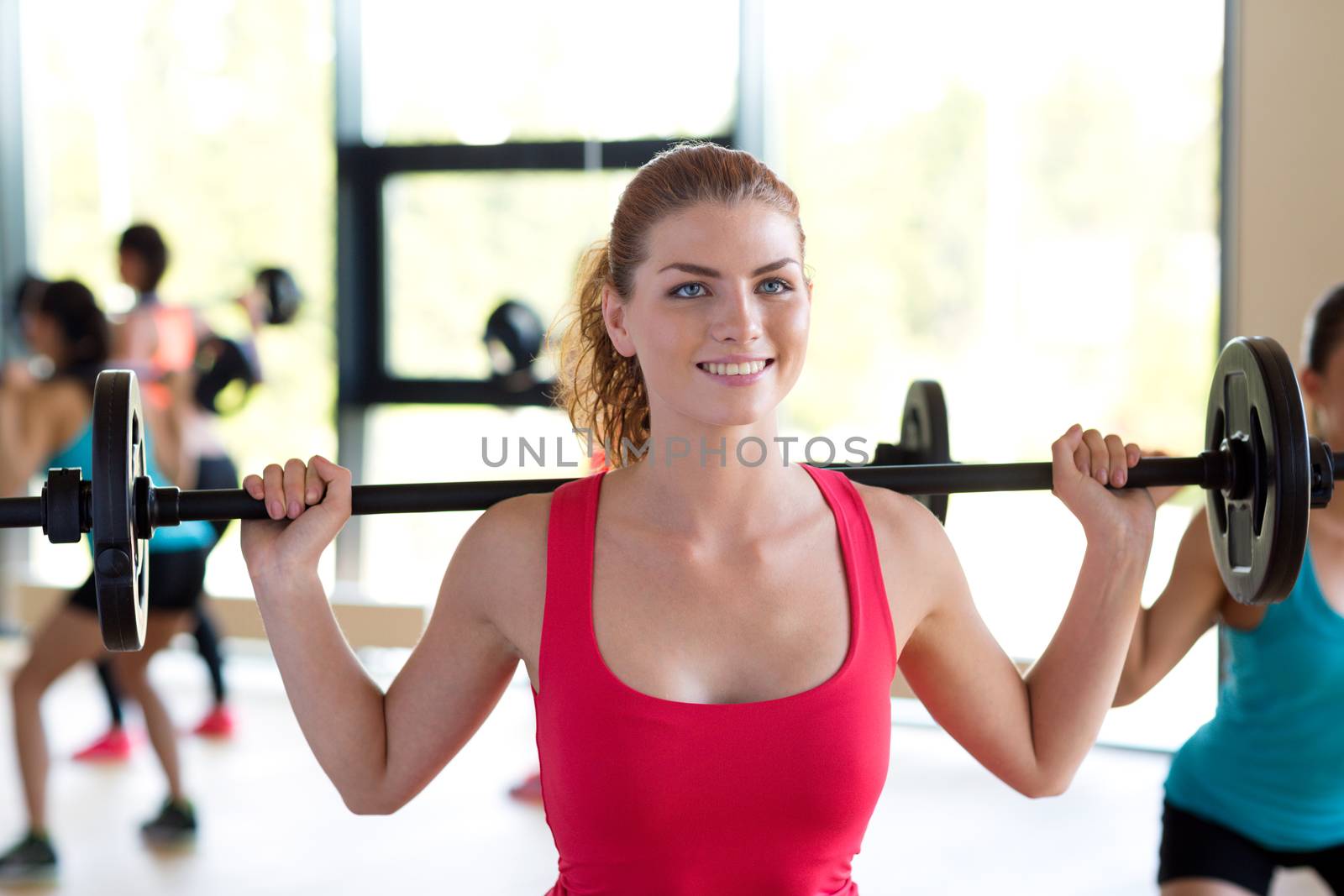 group of women with barbells in gym by dolgachov