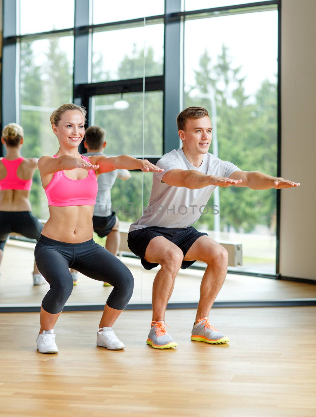 sport, fitness, lifestyle and people concept - smiling man and woman exercising in gym