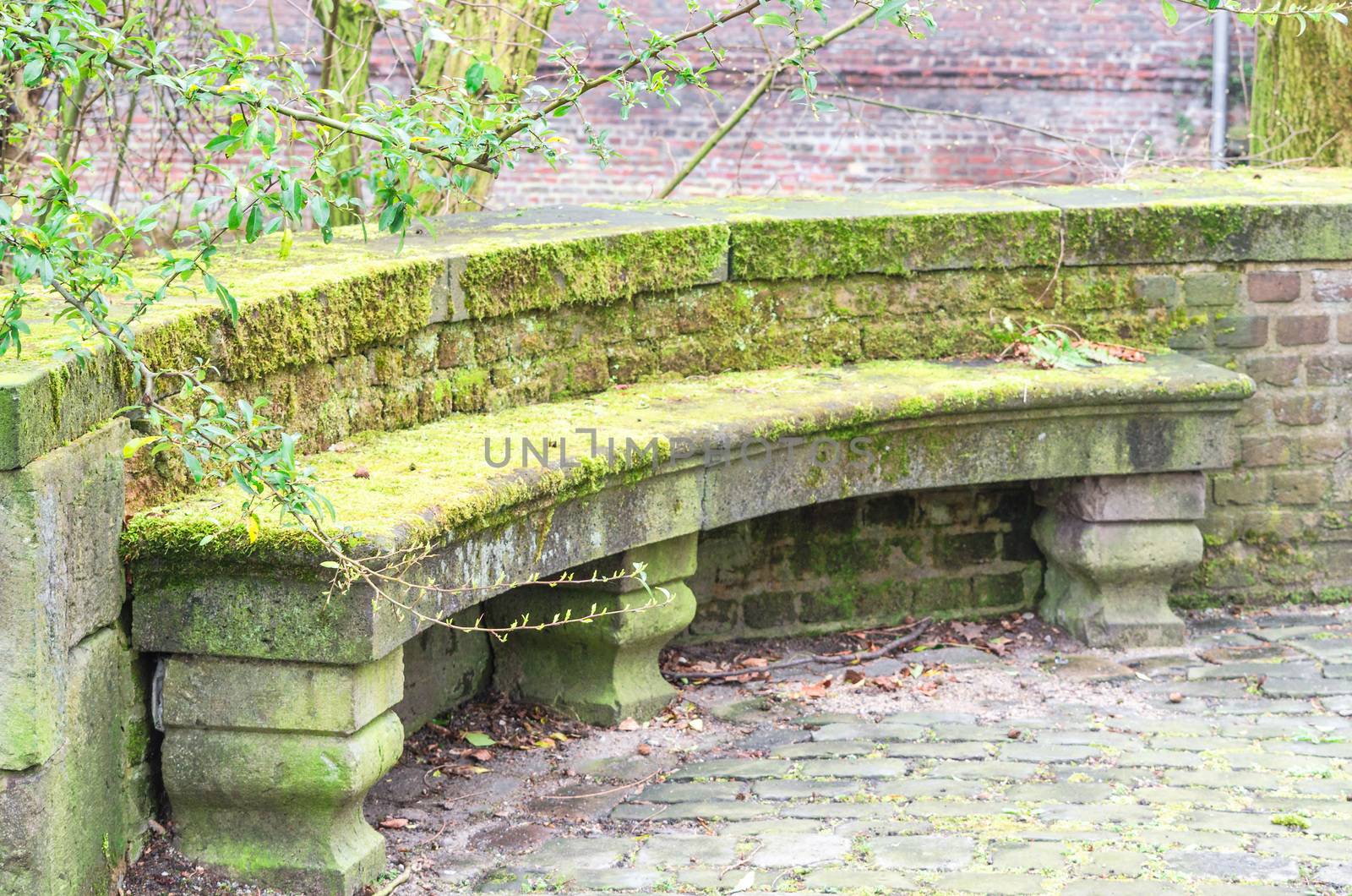 Old antique bench in stone in an old park.