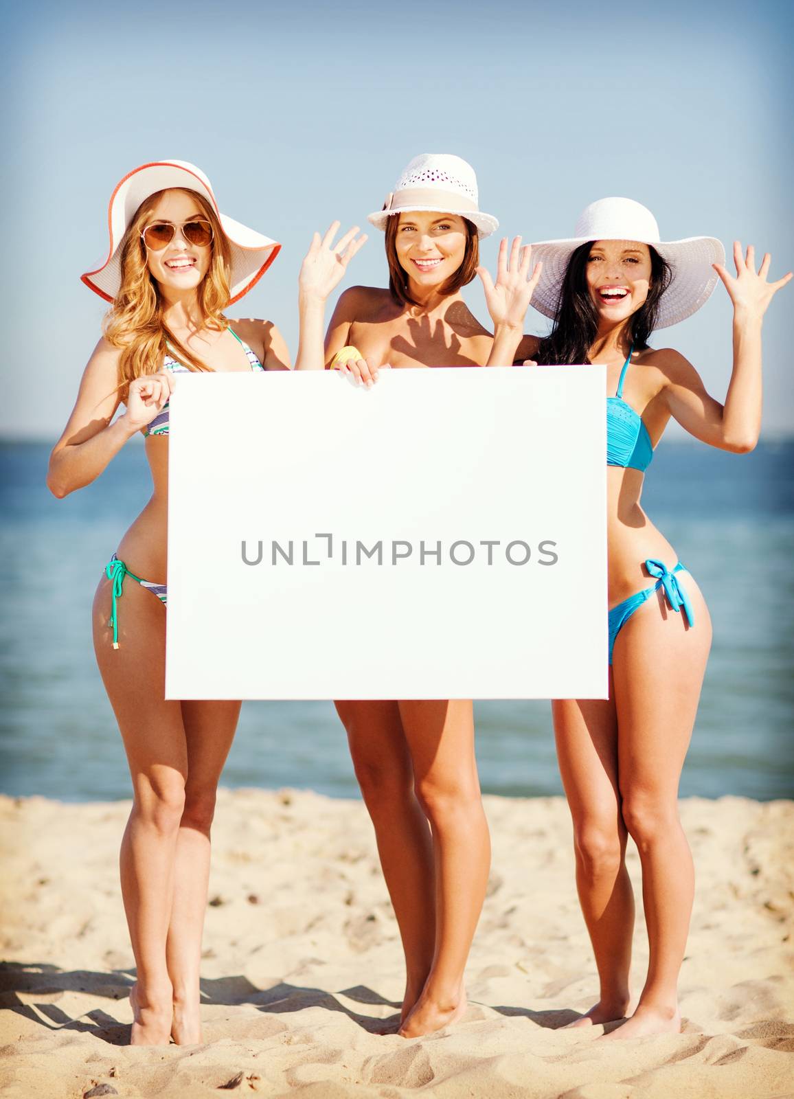girls with blank board on the beach by dolgachov