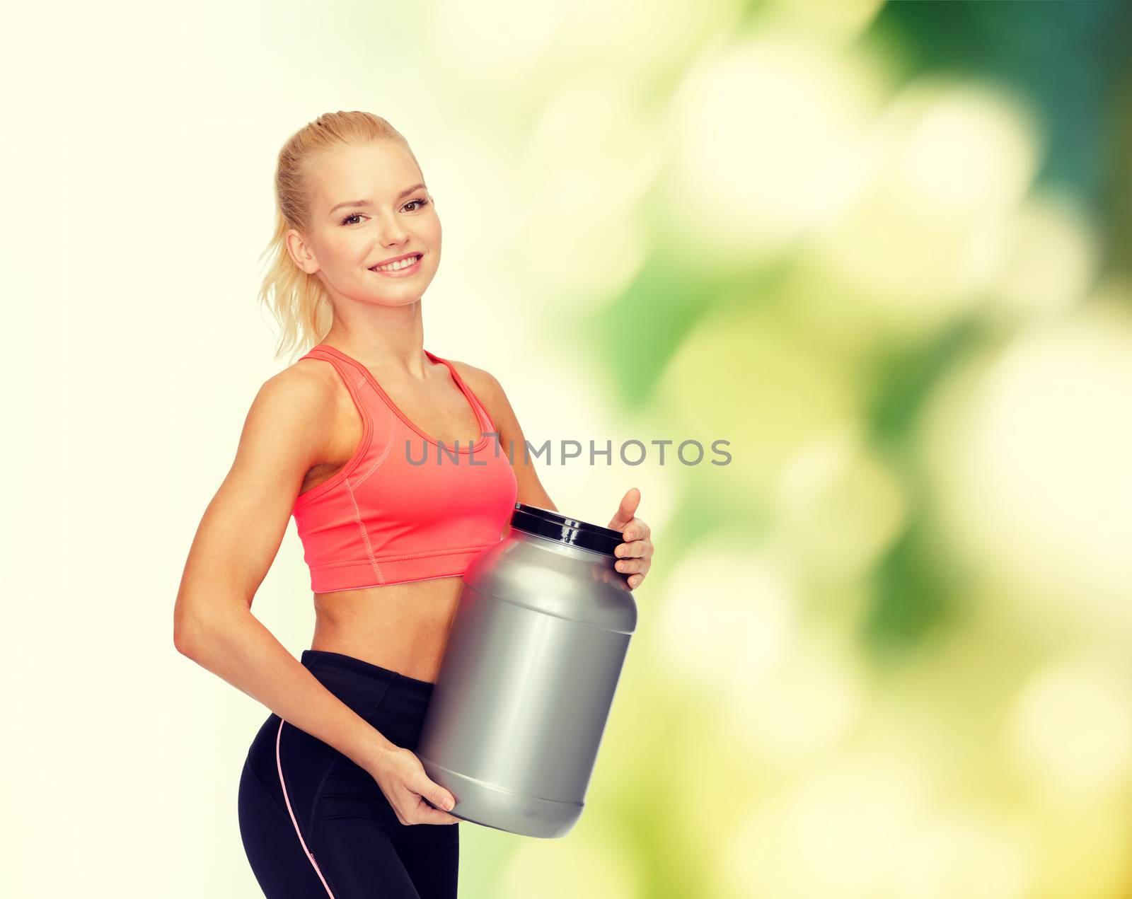 smiling sporty woman with jar of protein by dolgachov