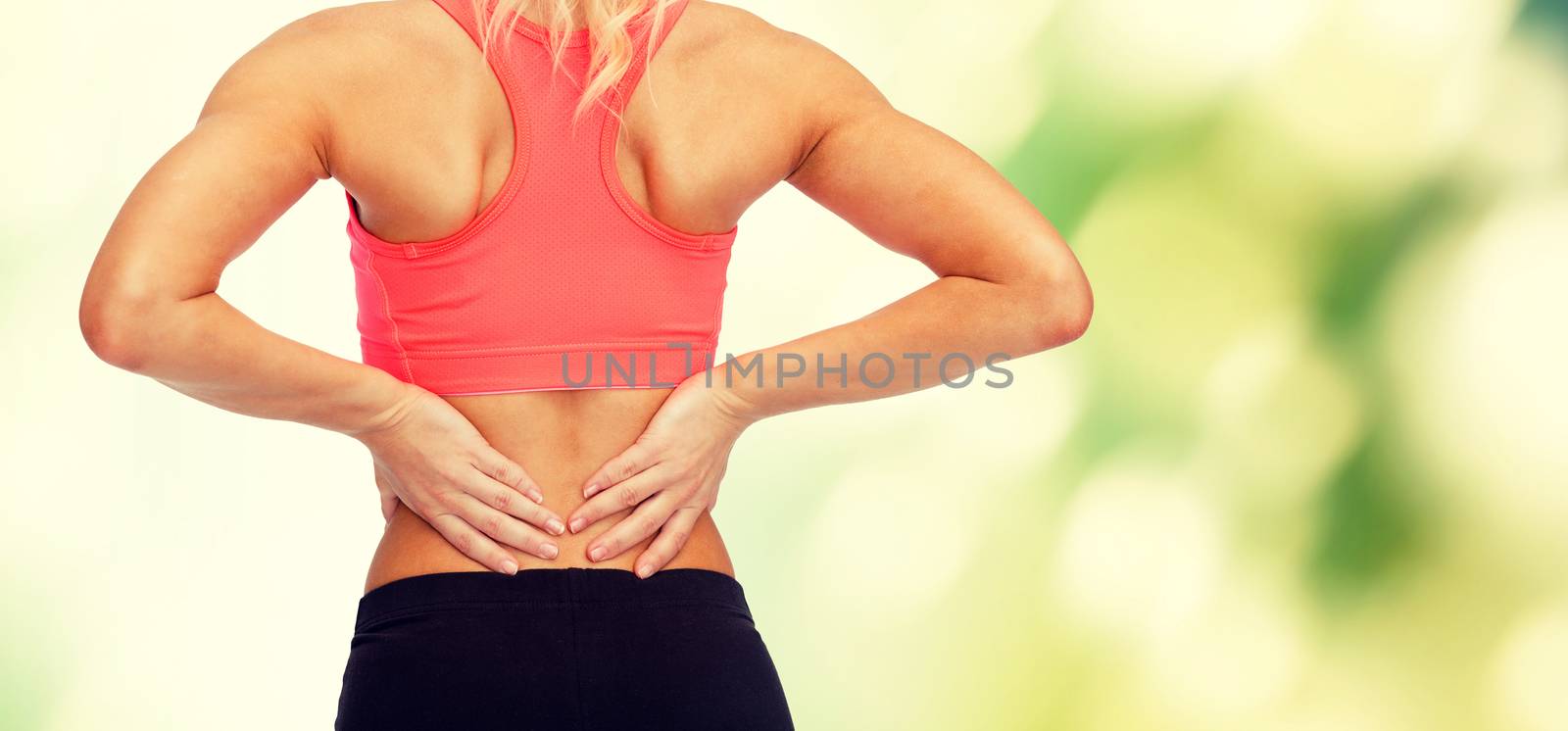 close up of sporty woman touching her back by dolgachov
