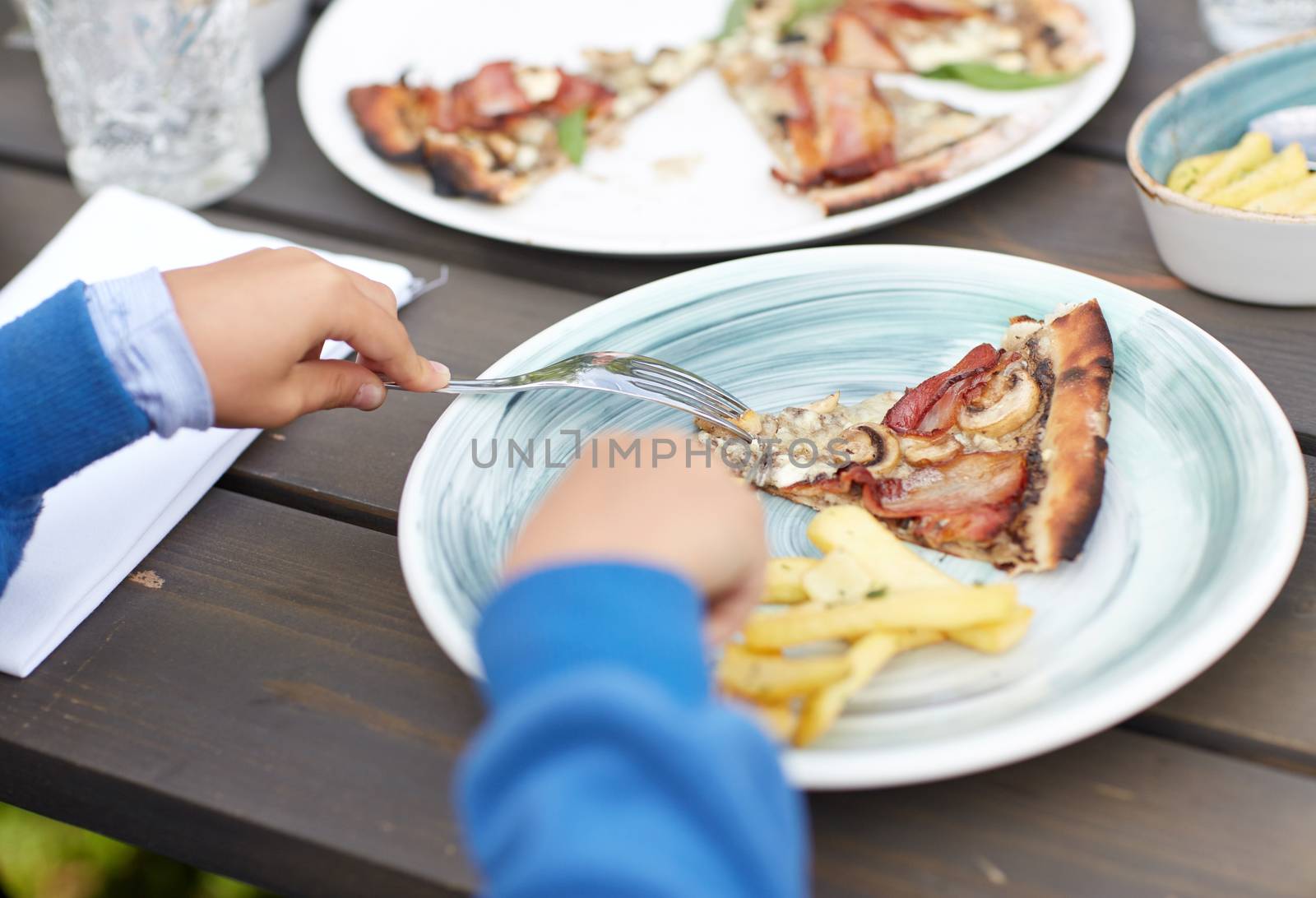 close up of child hands having dinner outdoors by dolgachov