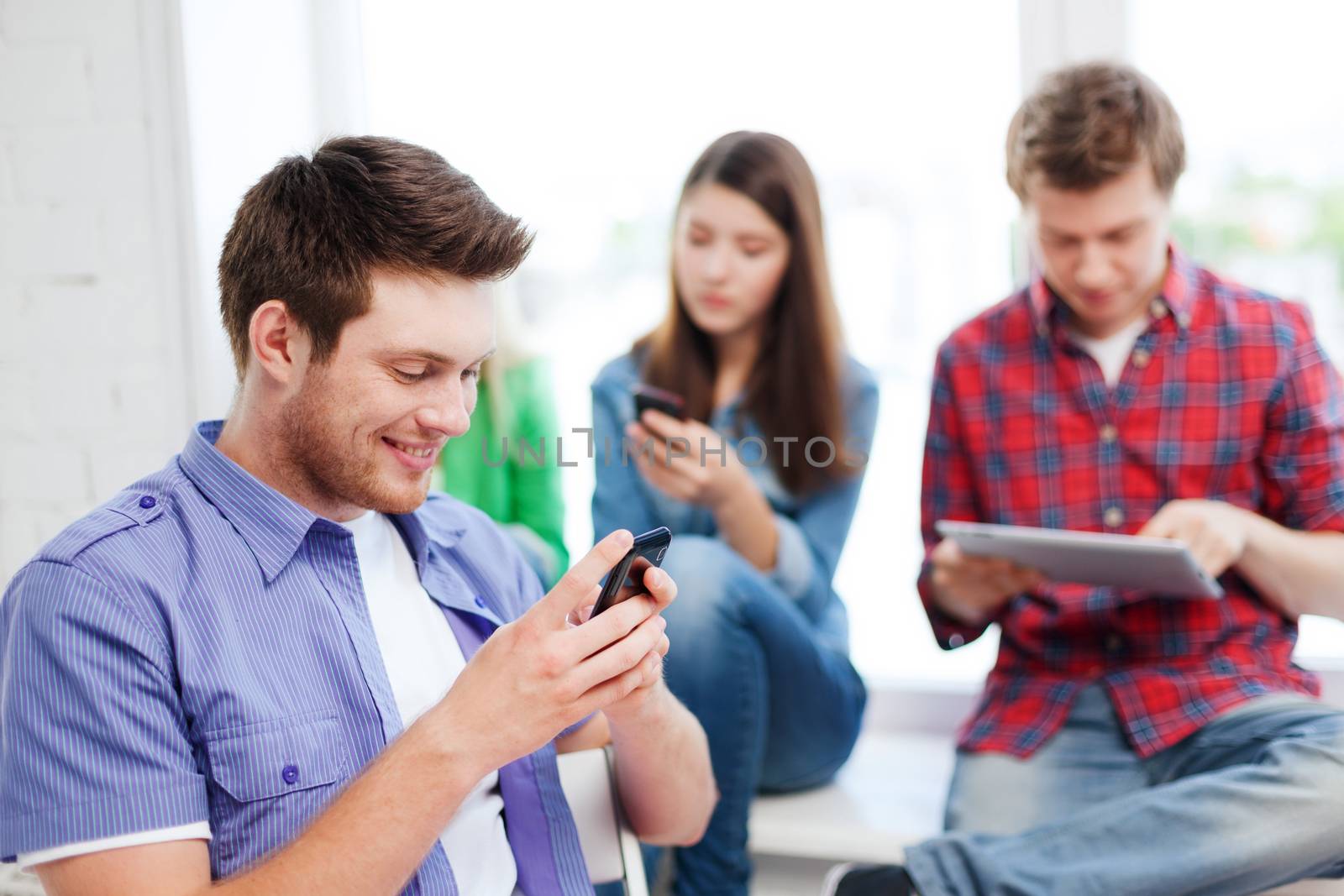 student looking into smartphone at school by dolgachov